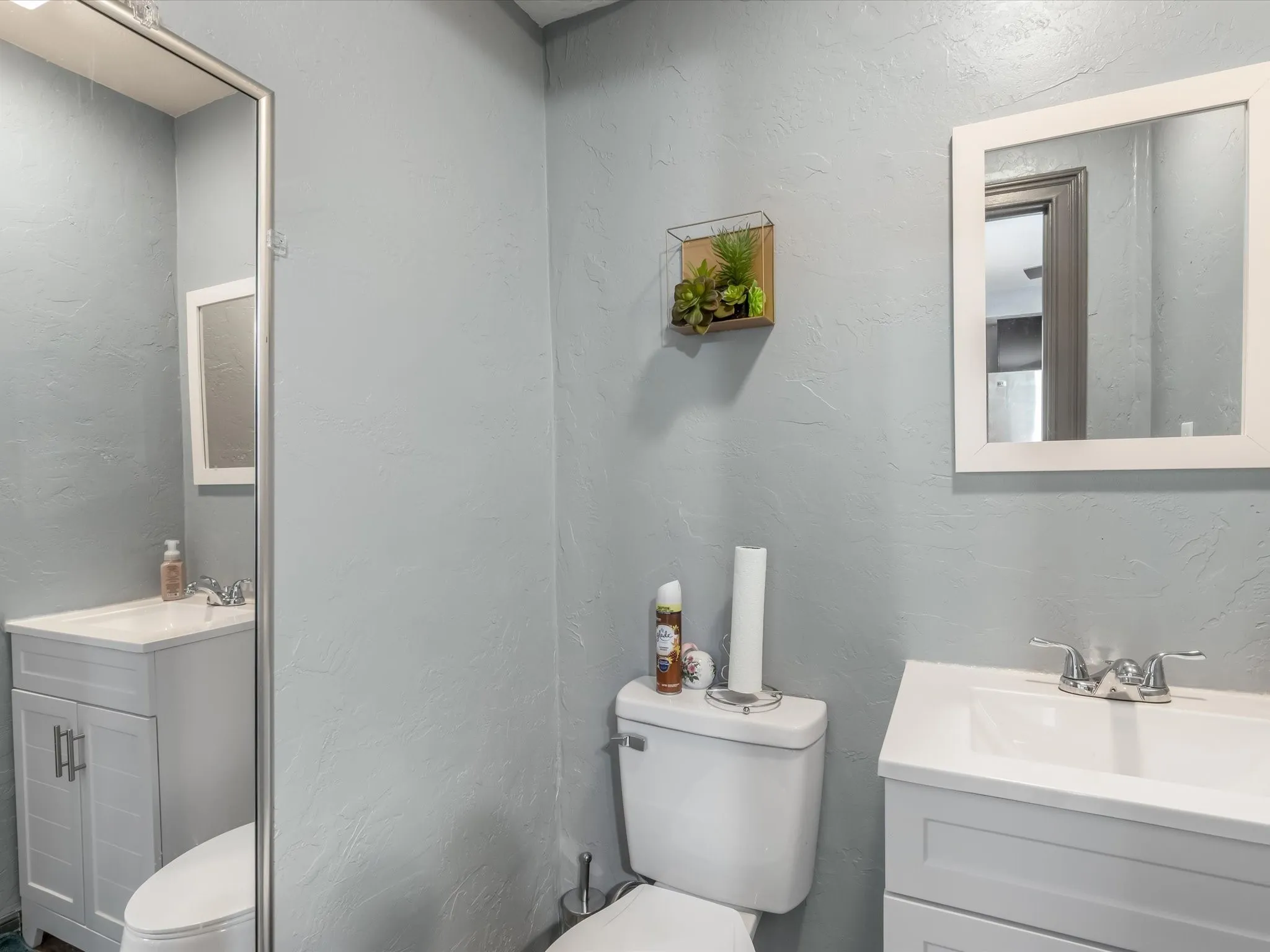 Half bath with vanity and a textured wall