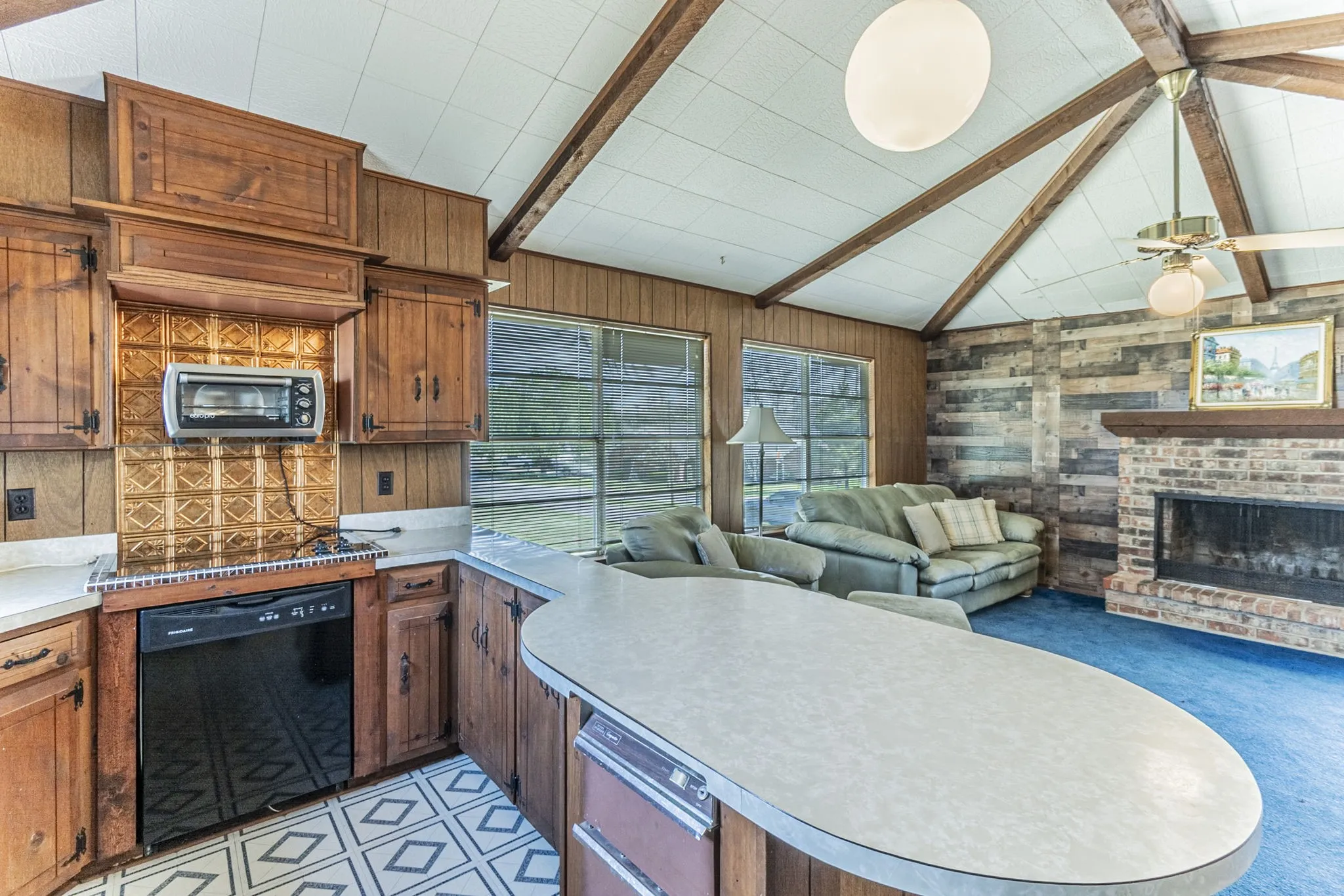 A view of the upstairs living room from the kitchen, showing the breakfast bar and trash compactor.