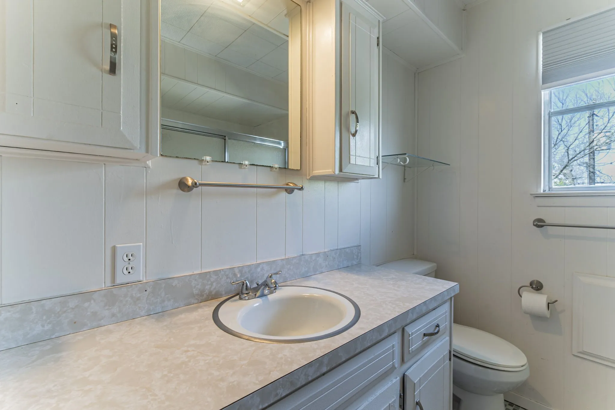The upstairs bathroom with a single sink & medicine cabinets.