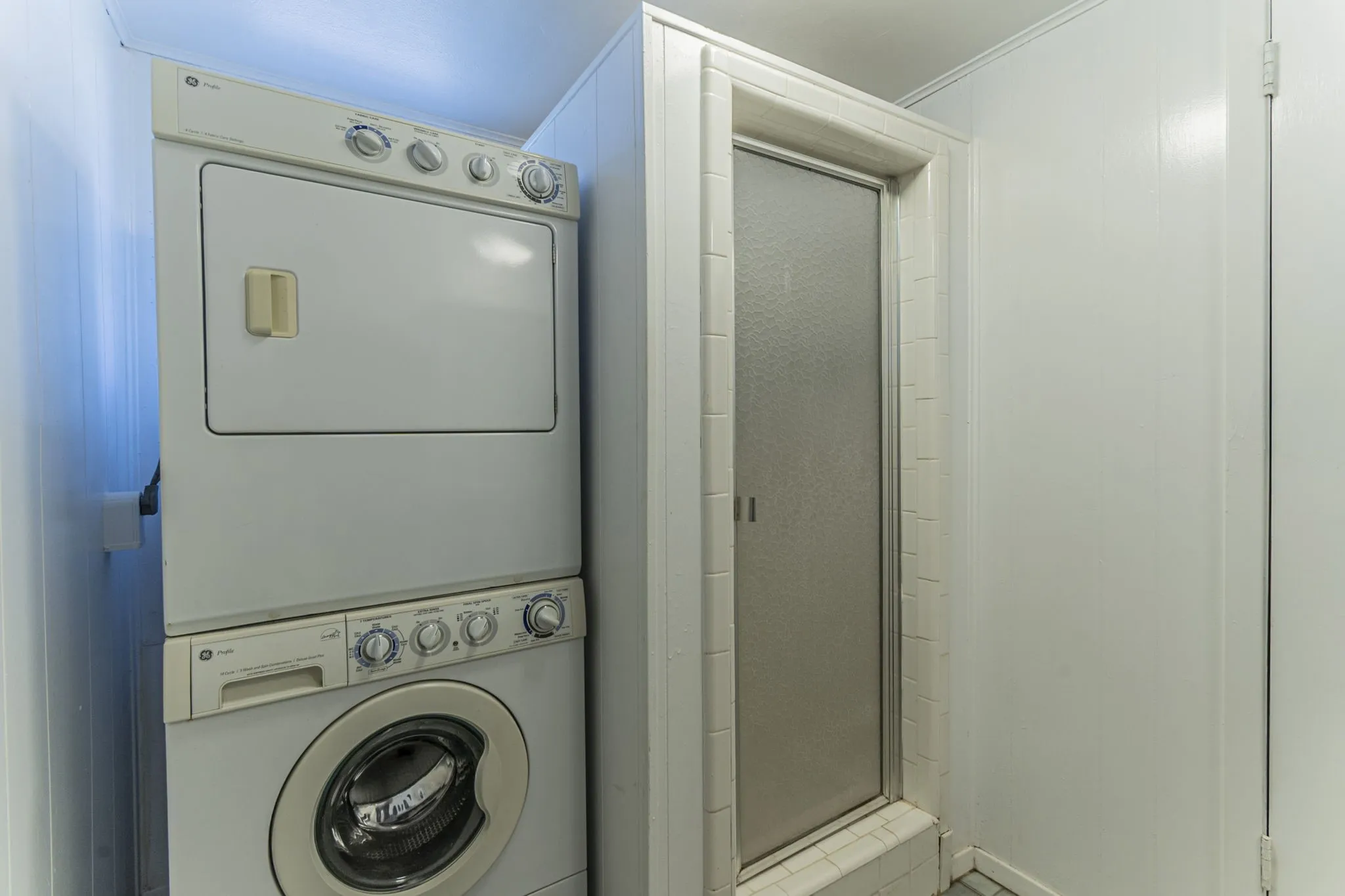 The downstairs bathroom includes a walk-in shower and the laundry room (stackable appliances remain). To the left is a doorway to the garage.