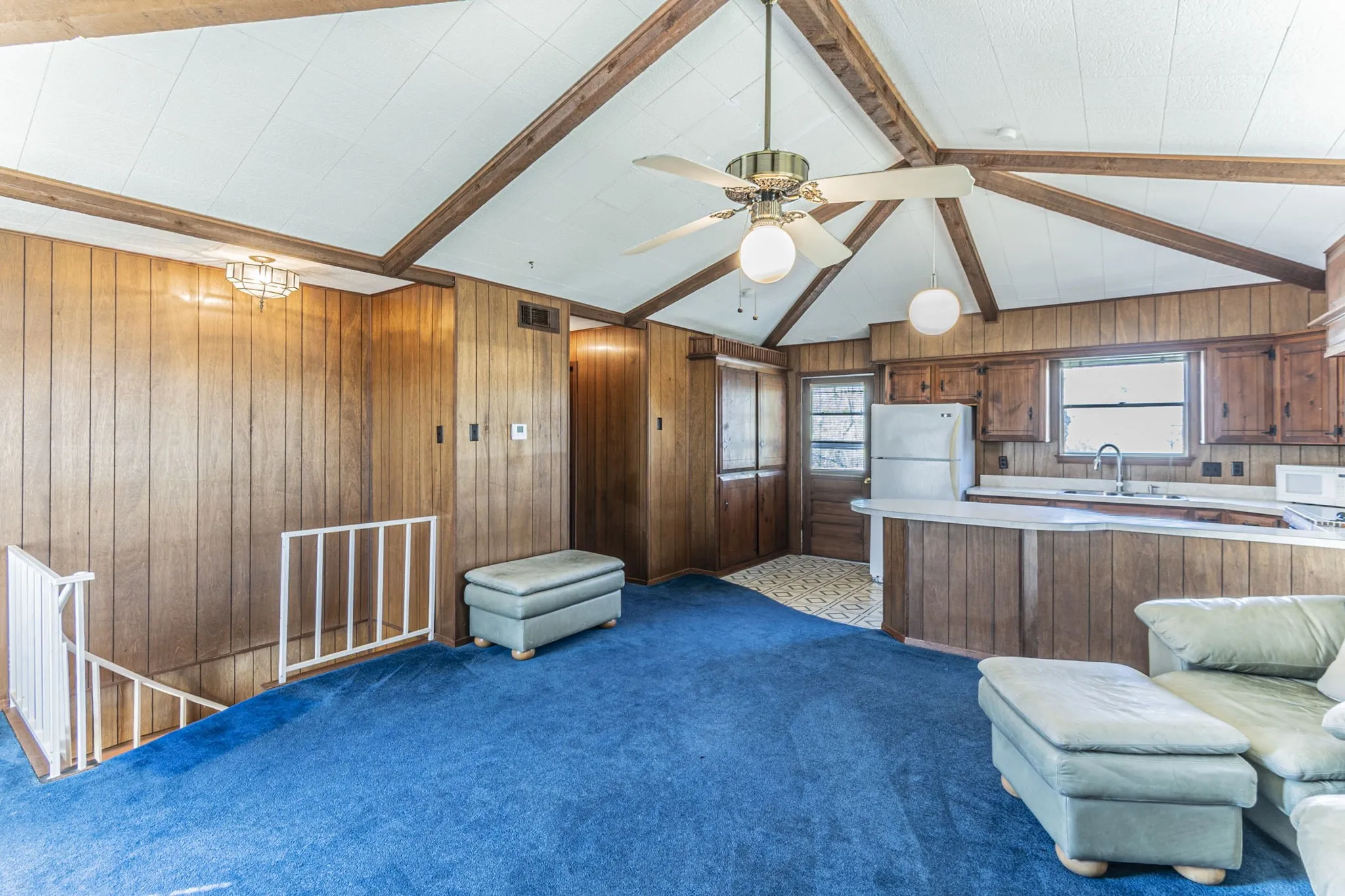The upstairs living/kitchen area is wide open and includes a breakfast bar - great for relaxing or entertaining! The hallway to the left leads to the bedrooms. Door at rear leads out to the deck. Furniture is negotiable.