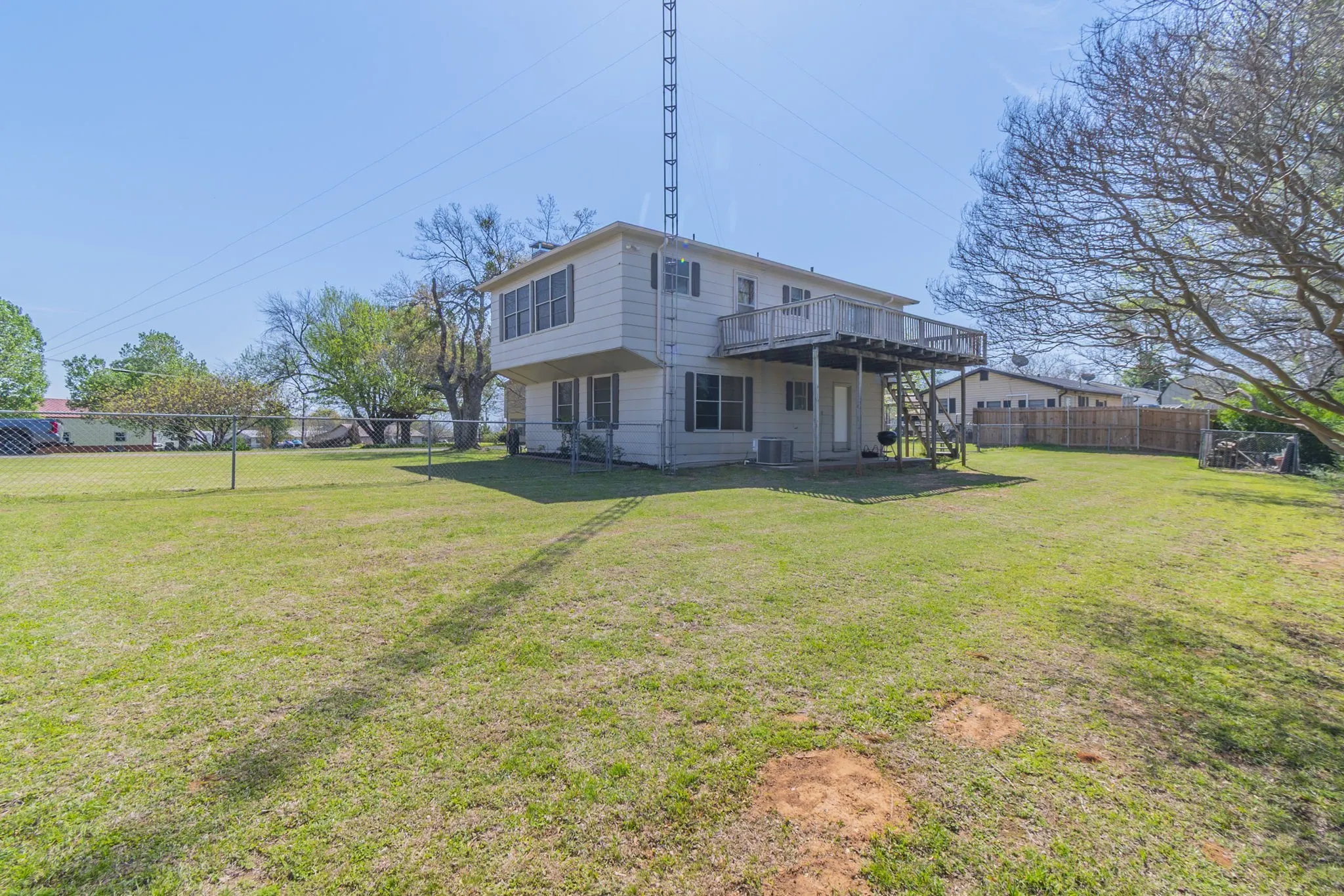 This view shows the size of the back yard and the deck across the back.