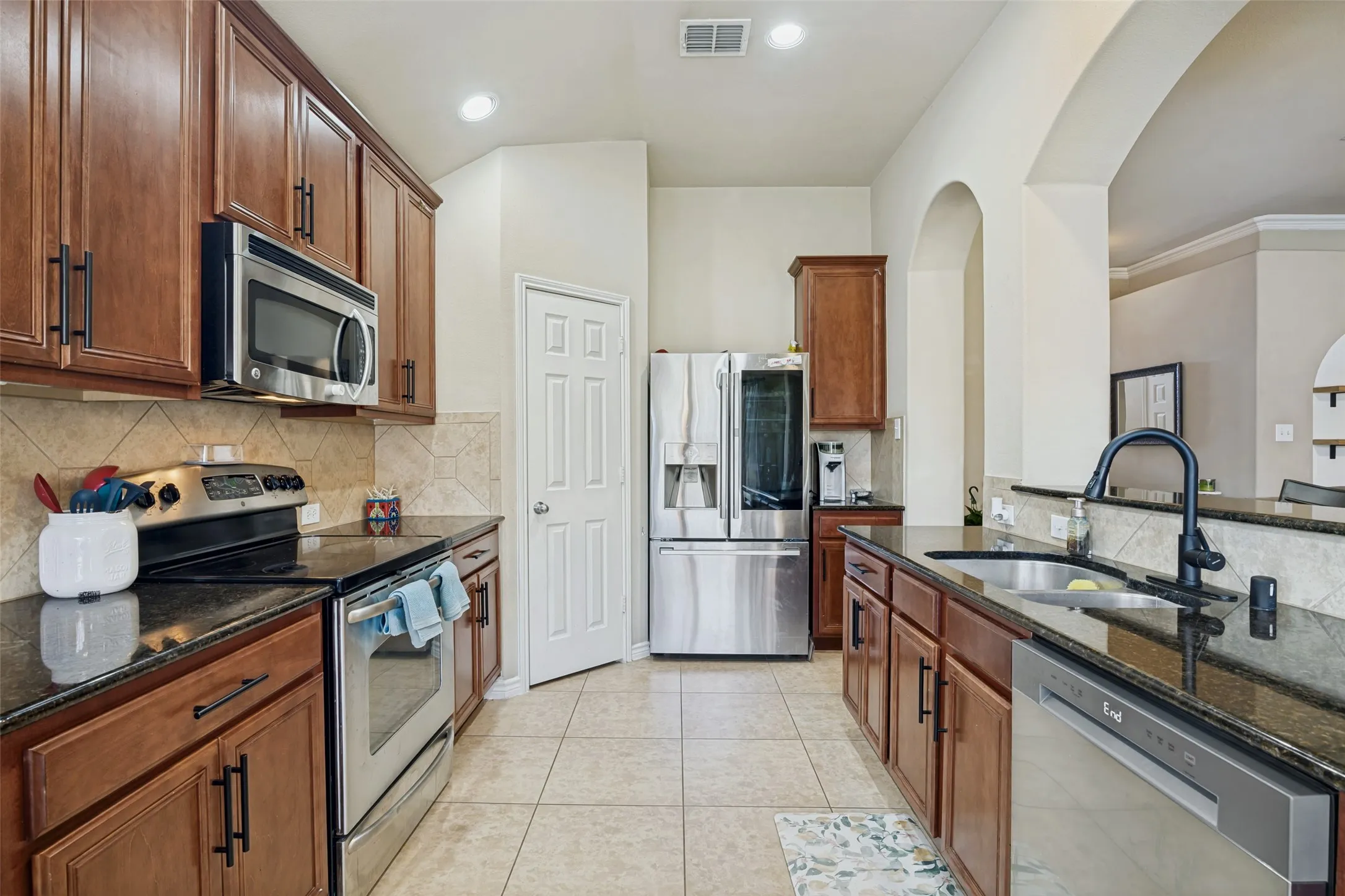 Warm wood cabinets and dark granite add warmth and character to the kitchen.