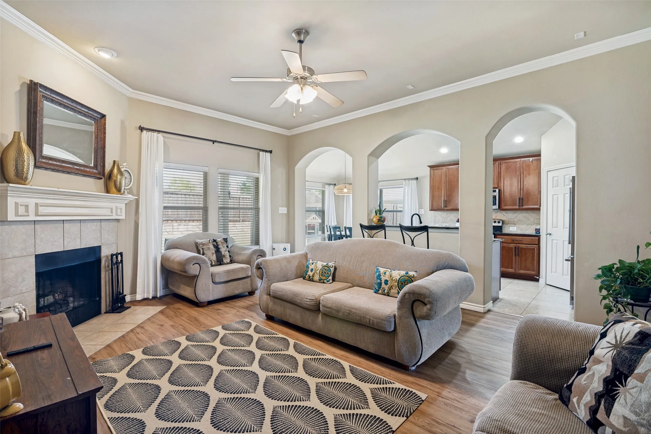 Light filled living room with arch details and a wood burning fireplace.