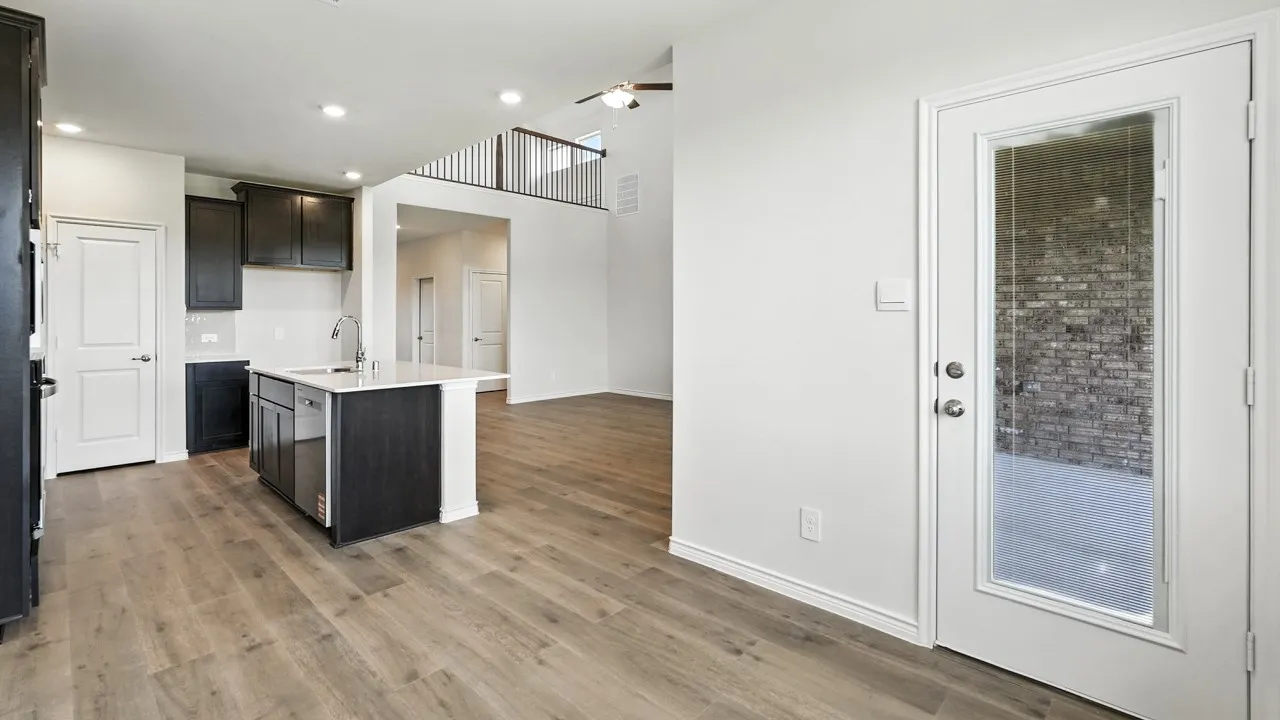 Kitchen with a center island with sink, light wood-style floors, light stone countertops, and recessed lighting