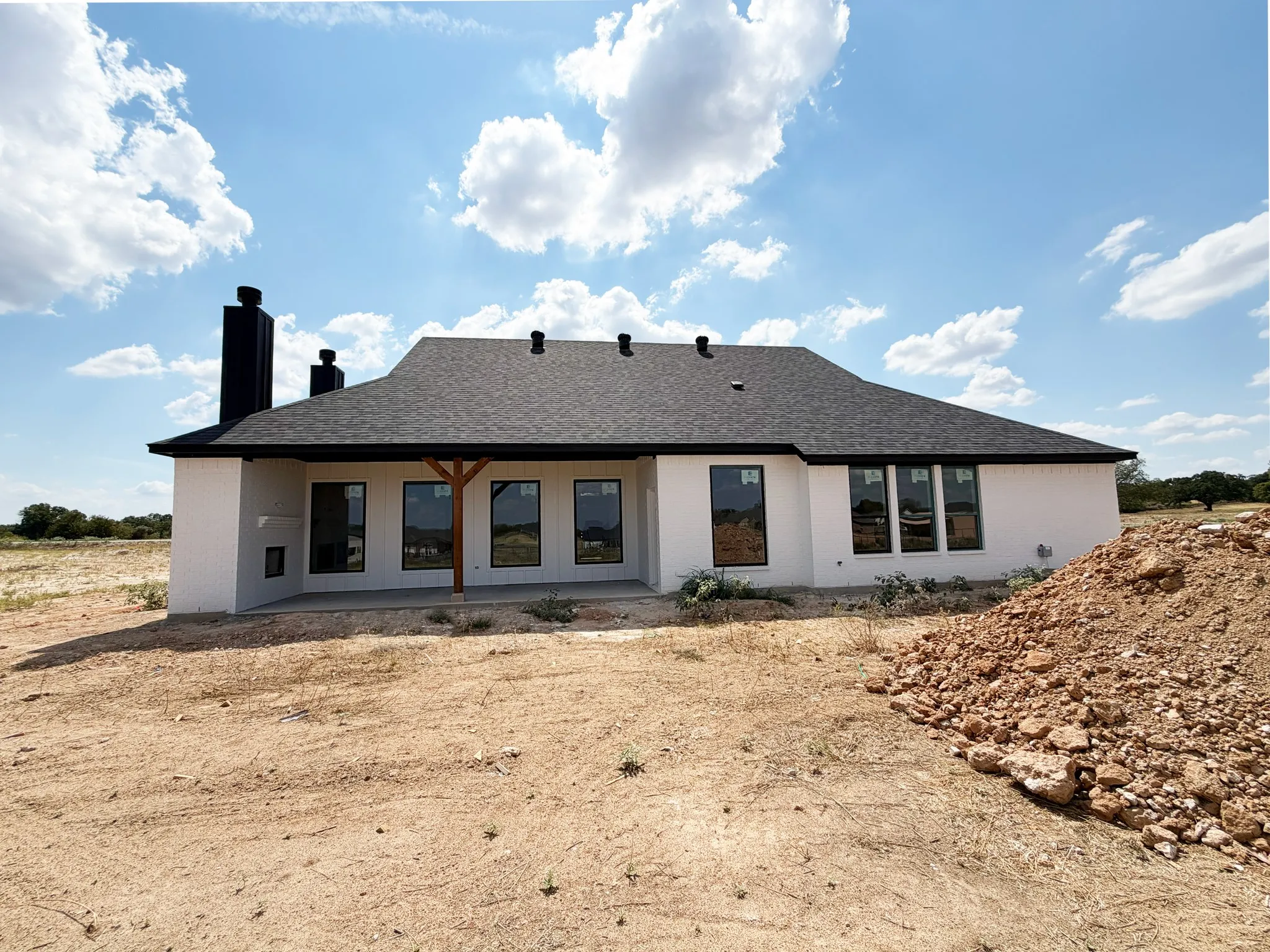 White stucco exterior with a dark asphalt shingle roof