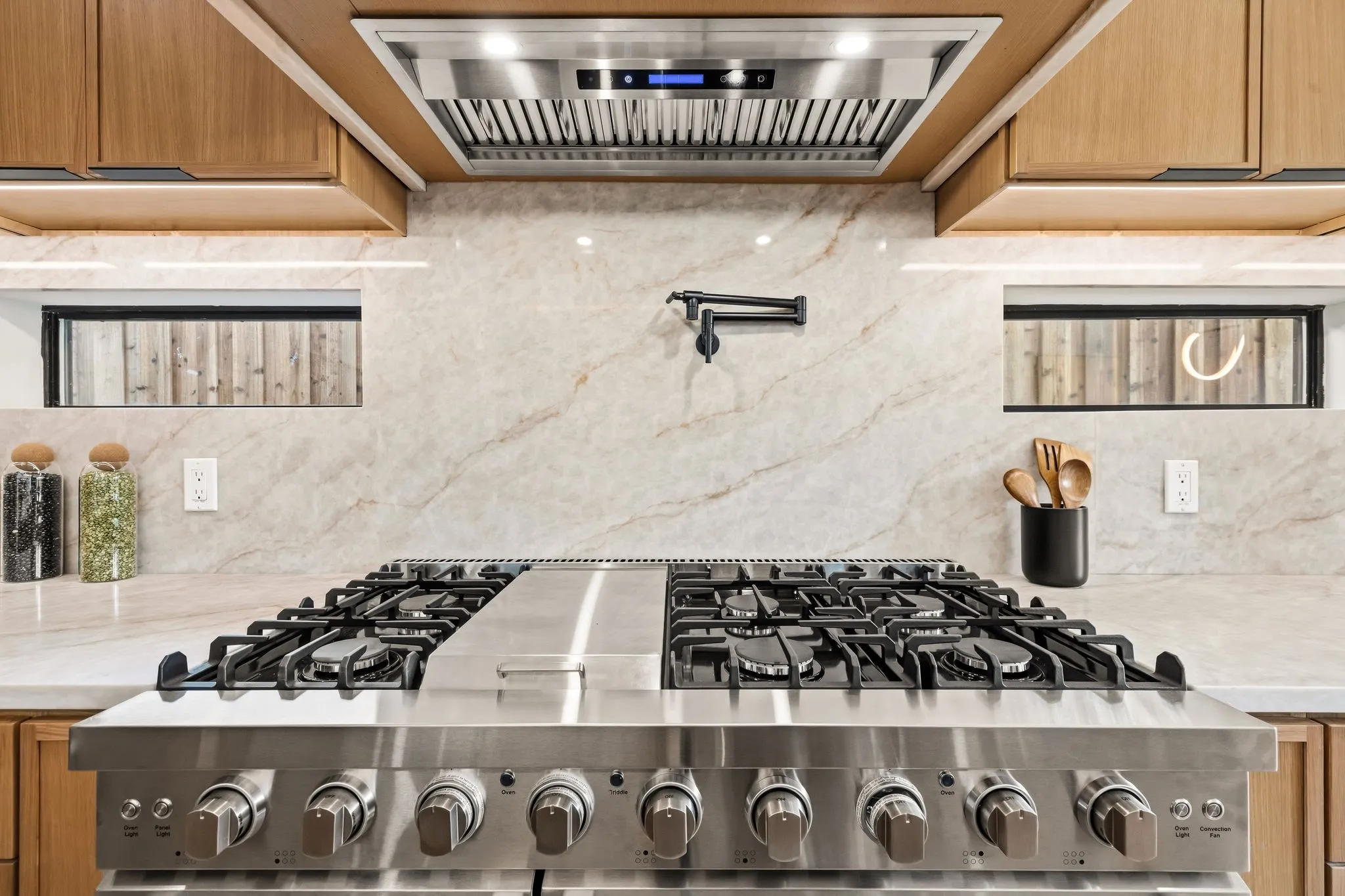 Stainless steel professional-grade range with multiple burners and griddle