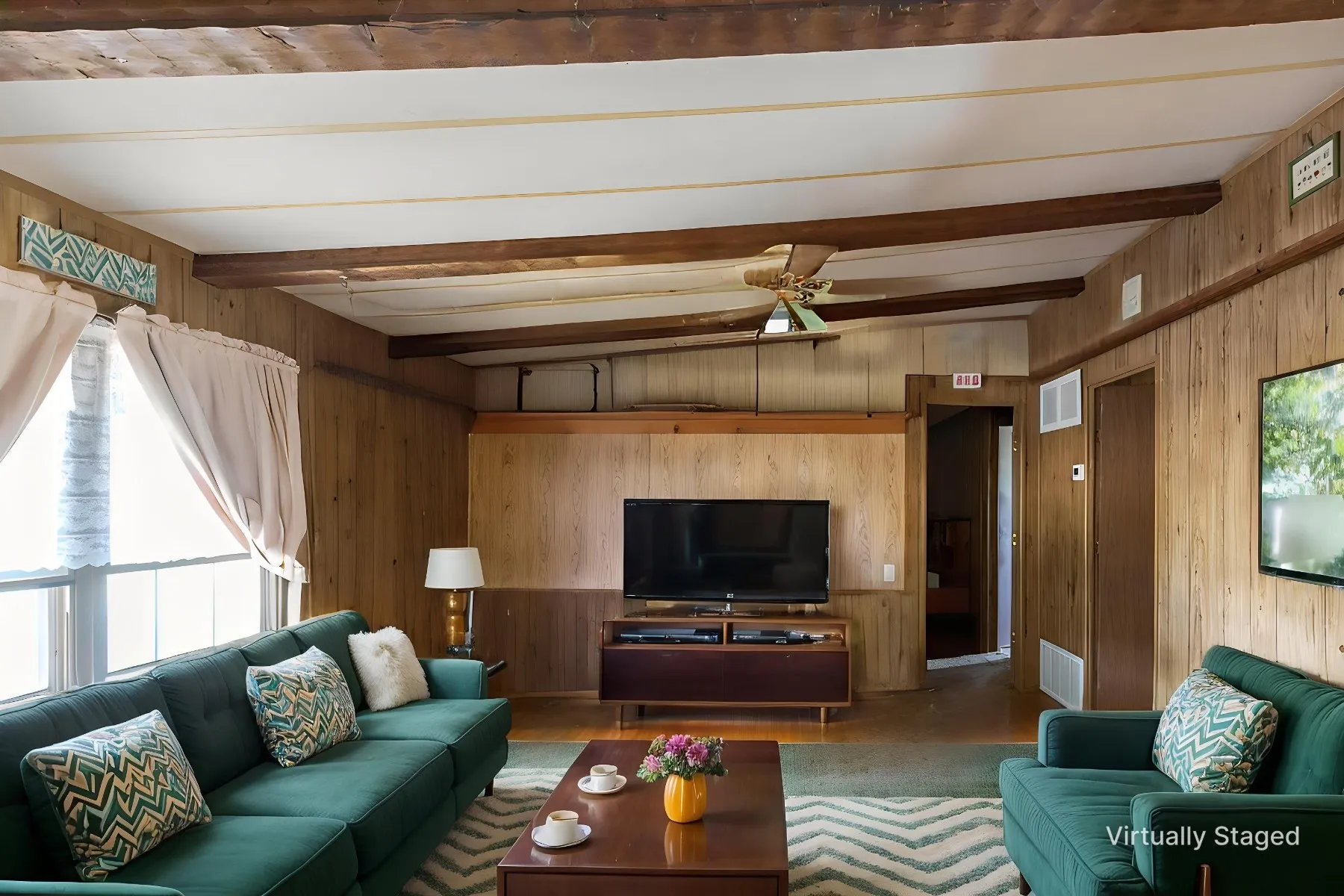 Living area featuring wood paneling throughout, exposed ceiling beams, and a ceiling fan - virtually staged