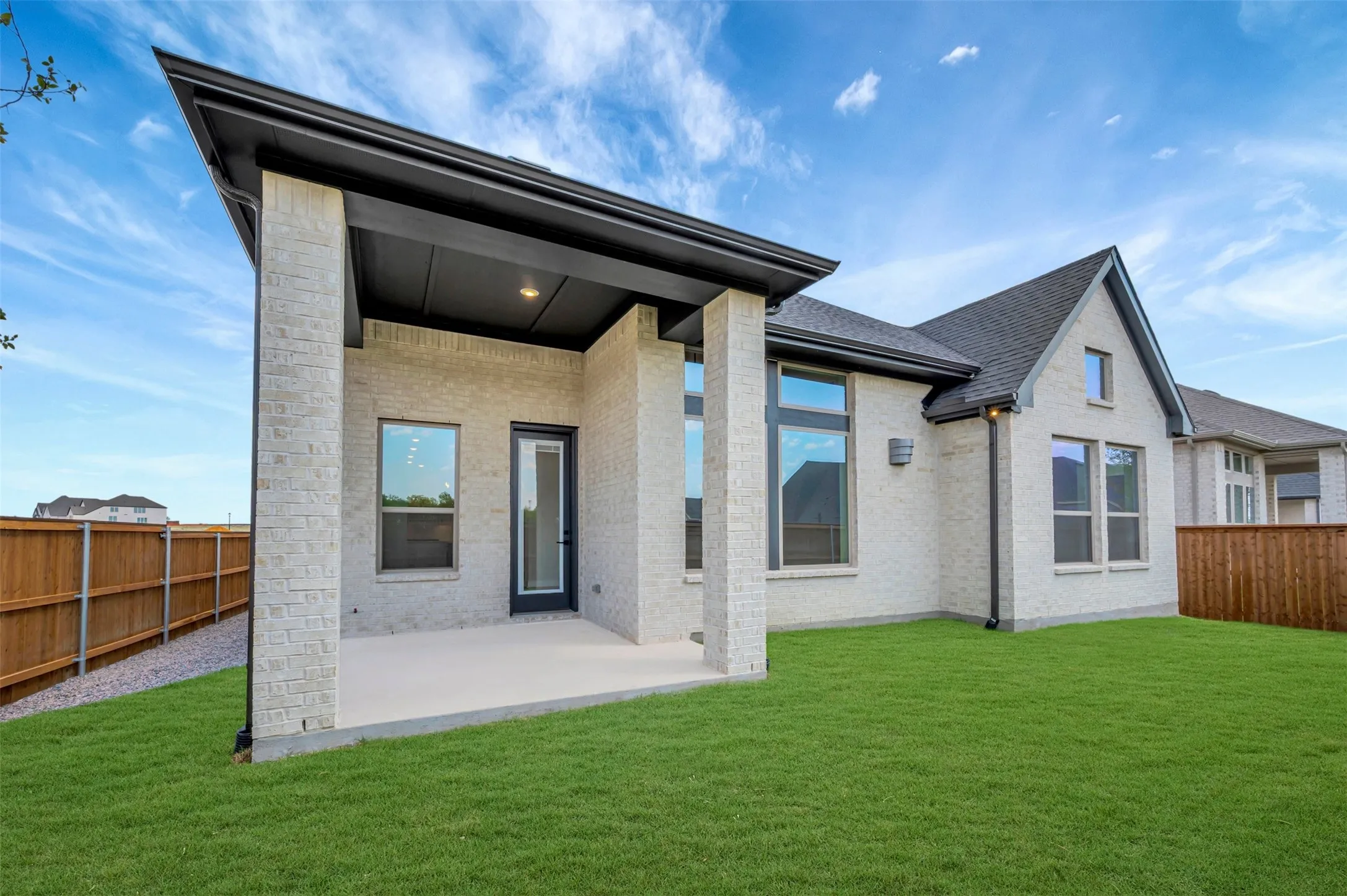 Expansive backyard featuring a covered patio, a manicured lawn, and a privacy fence
