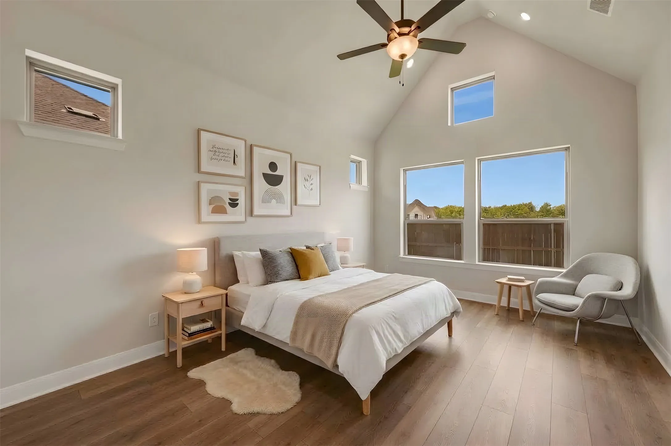 Vaulted ceiling, wood-finish flooring, multiple windows, recessed lighting, and a ceiling fan with integrated lighting