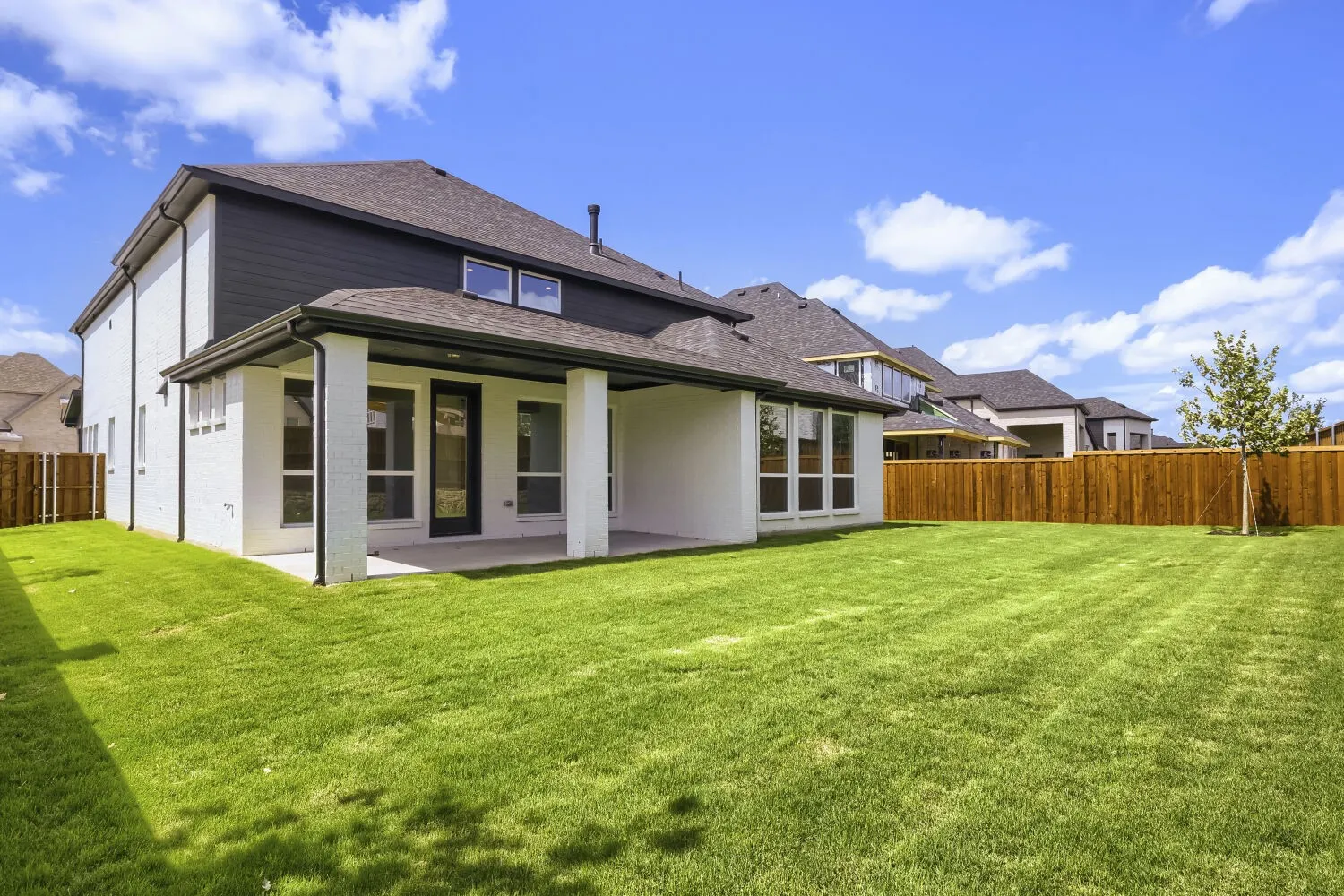Expansive green lawn with a newly installed wooden privacy fence