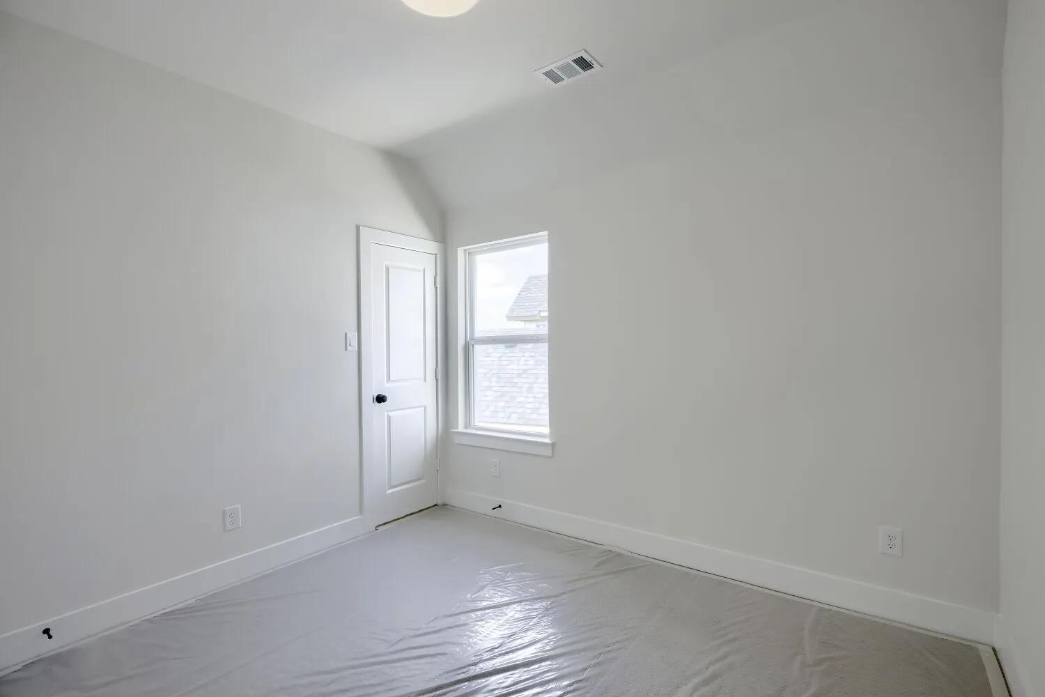 Bright room featuring a single window, white trim, and a flush-mount ceiling light
