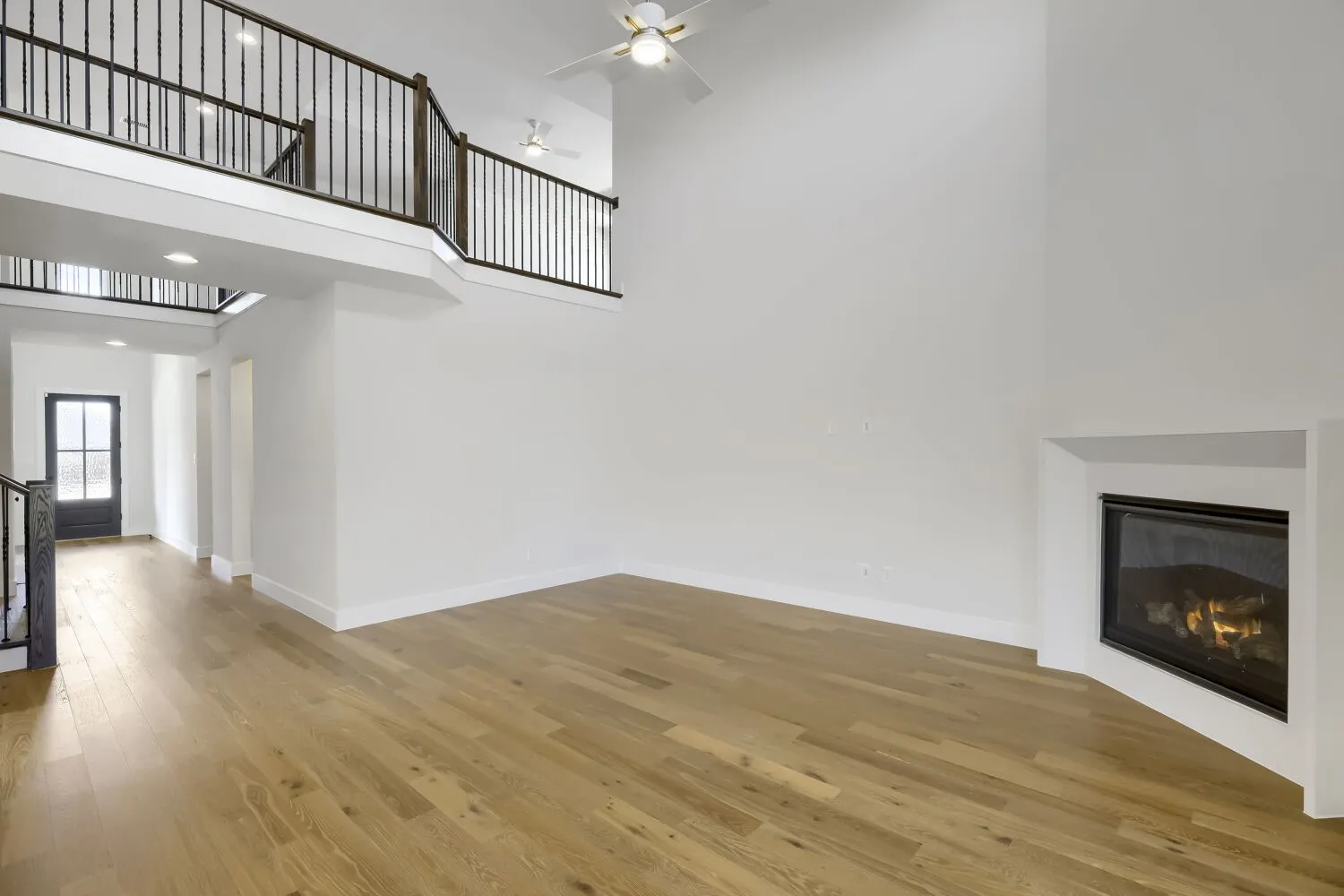 Open-concept living area featuring high ceilings and wood-finish flooring