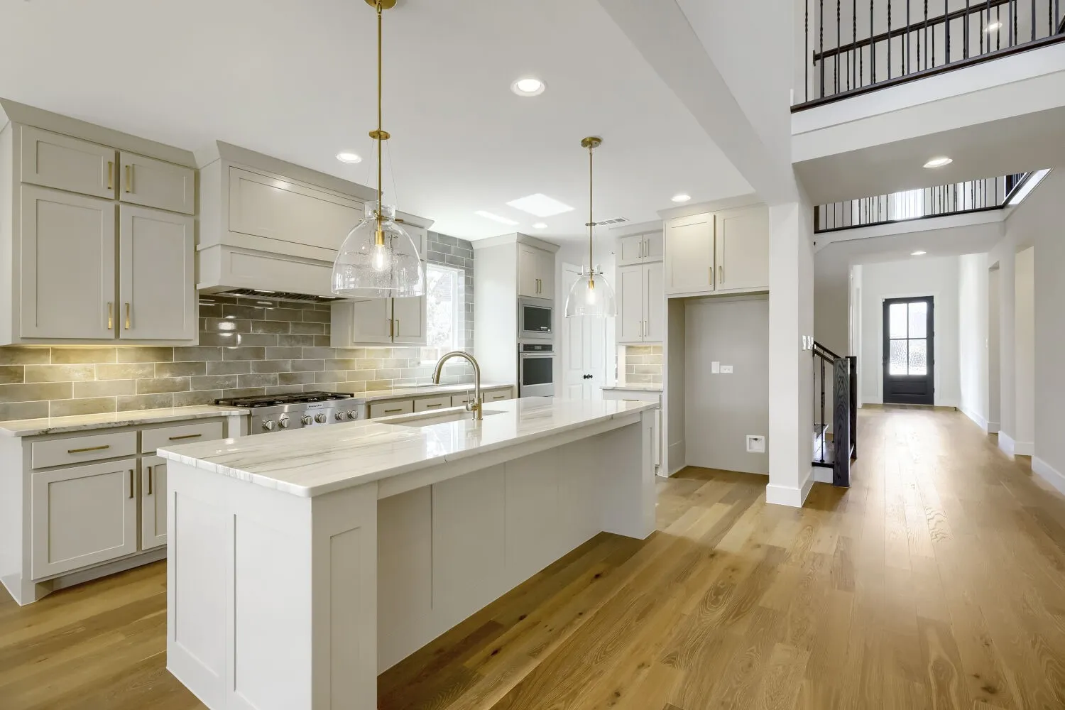 Gourmet kitchen with a large island, stainless steel appliances, stone countertops, and a subway tile backsplash