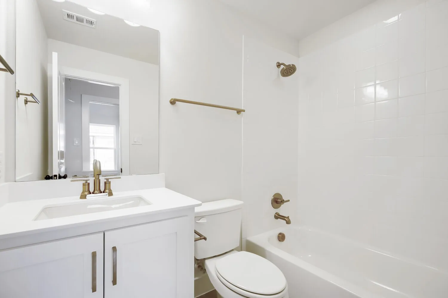 Bathroom featuring a white vanity with integrated sink, bronze-finish faucet, and coordinating hardware