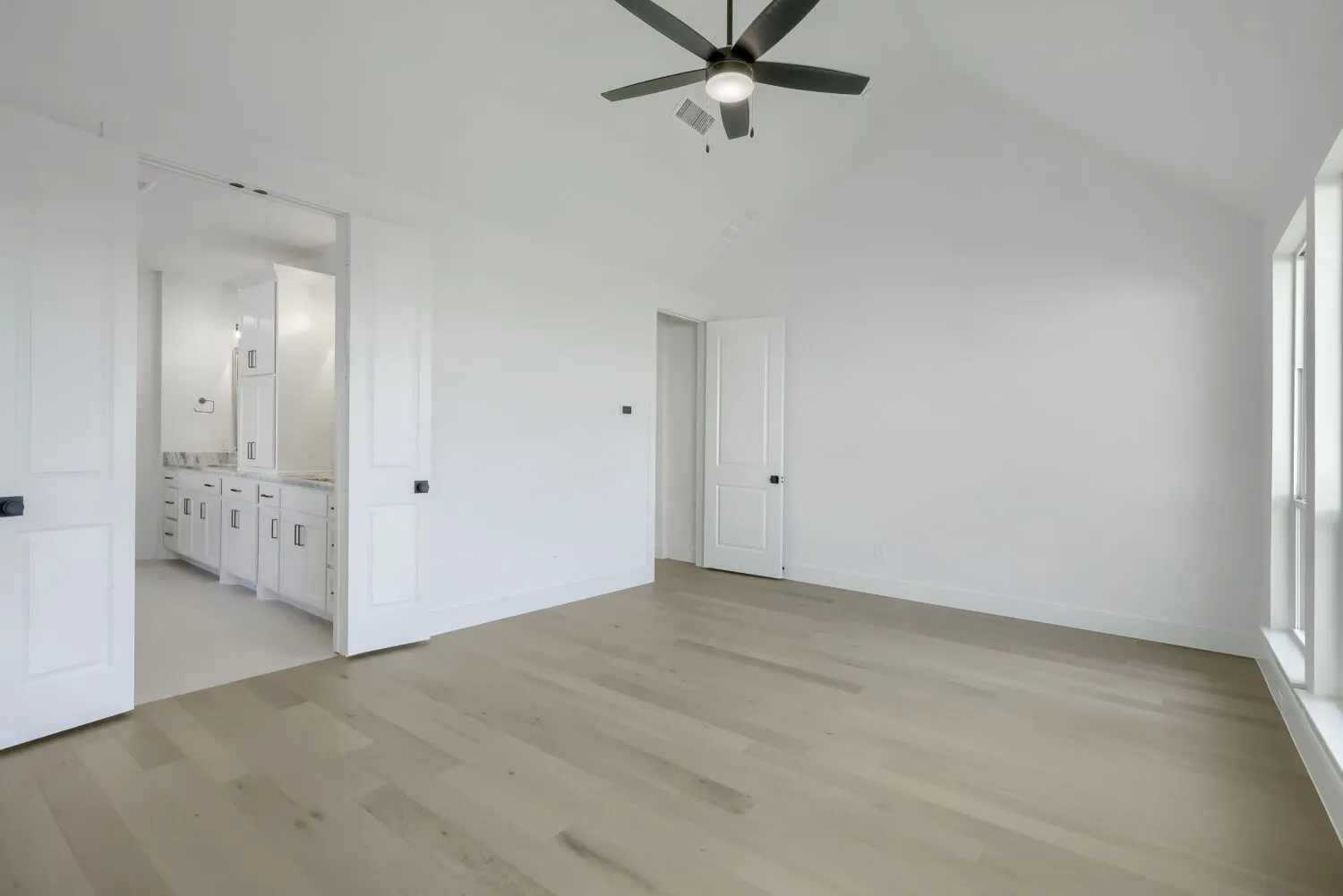 Vaulted ceiling with a ceiling fan and light fixture