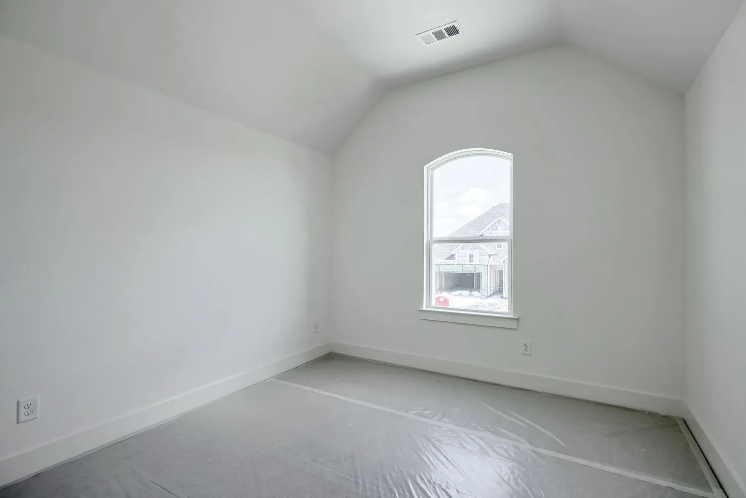 Room featuring a vaulted ceiling and an arched window