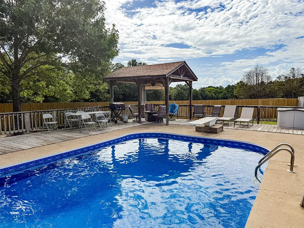View of pool featuring a gazebo, a fenced backyard, and a wooden deck
