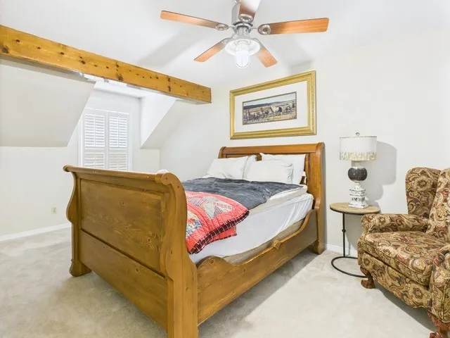 Carpeted bedroom with baseboards and a ceiling fan