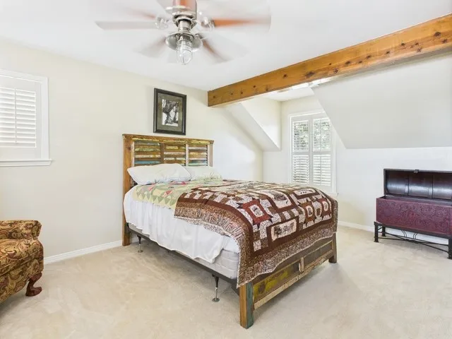 Carpeted bedroom featuring baseboards and a ceiling fan