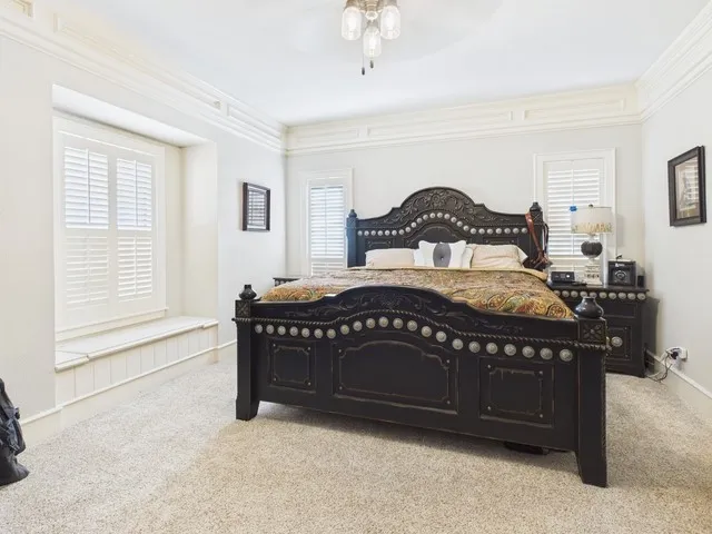 Bedroom featuring carpet floors, crown molding, and ceiling fan