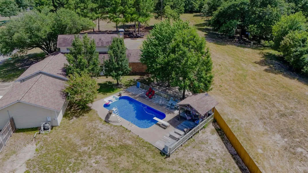 Aerial view of property and surrounding area featuring a pool area