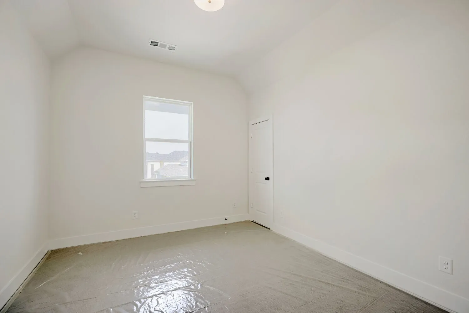 Room featuring a vaulted ceiling and a single window with white trim