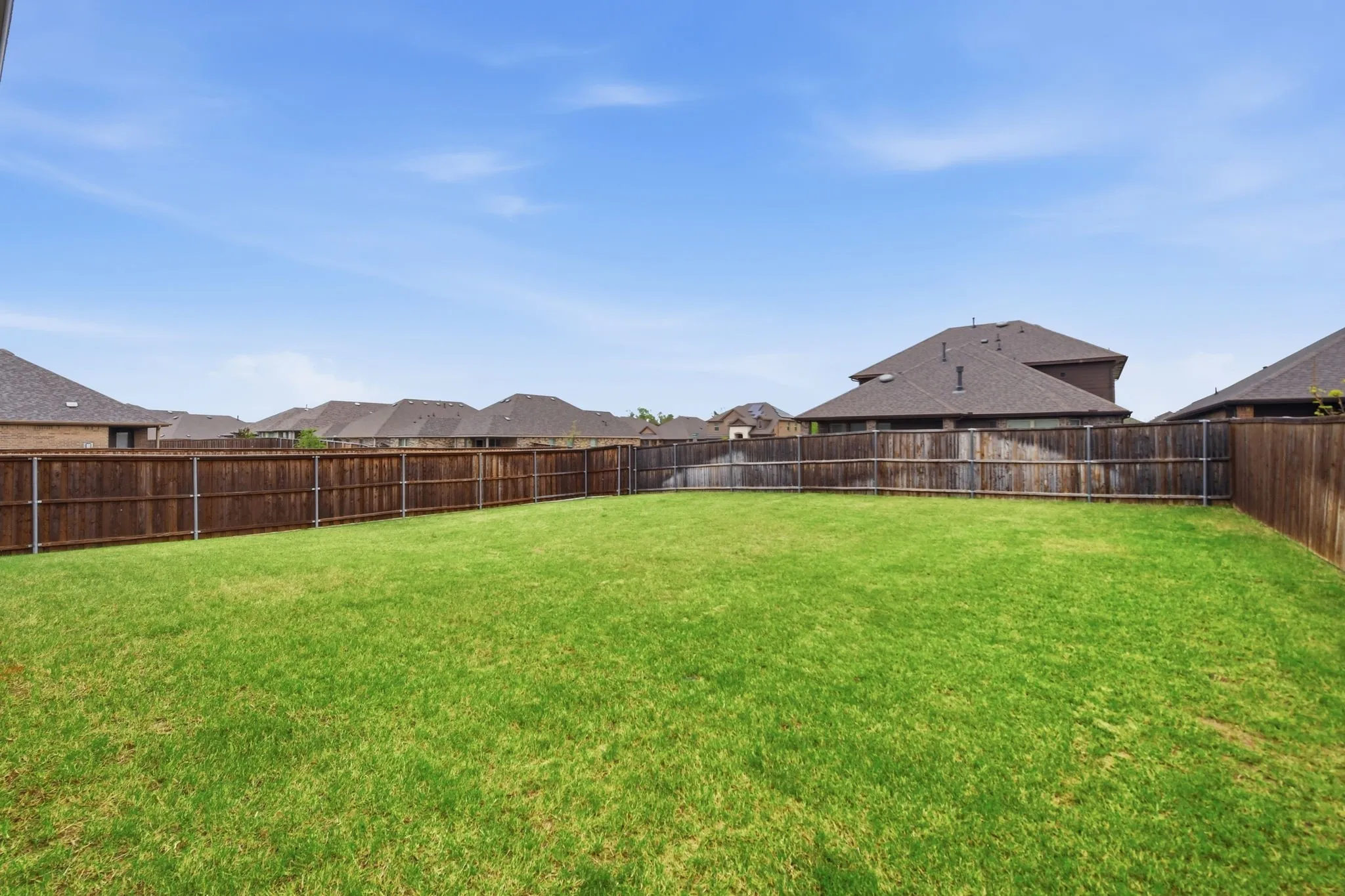 Fenced backyard featuring a residential view