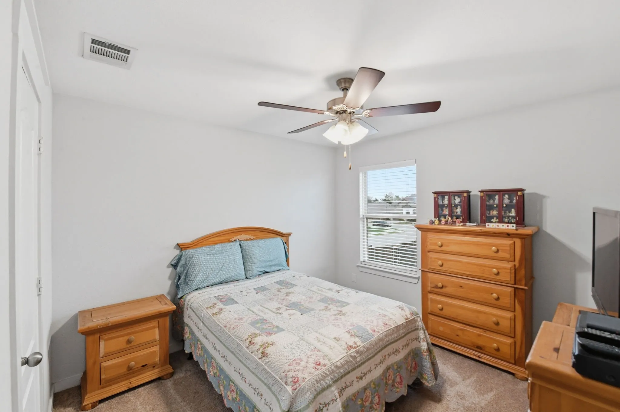 Carpeted bedroom with a ceiling fan