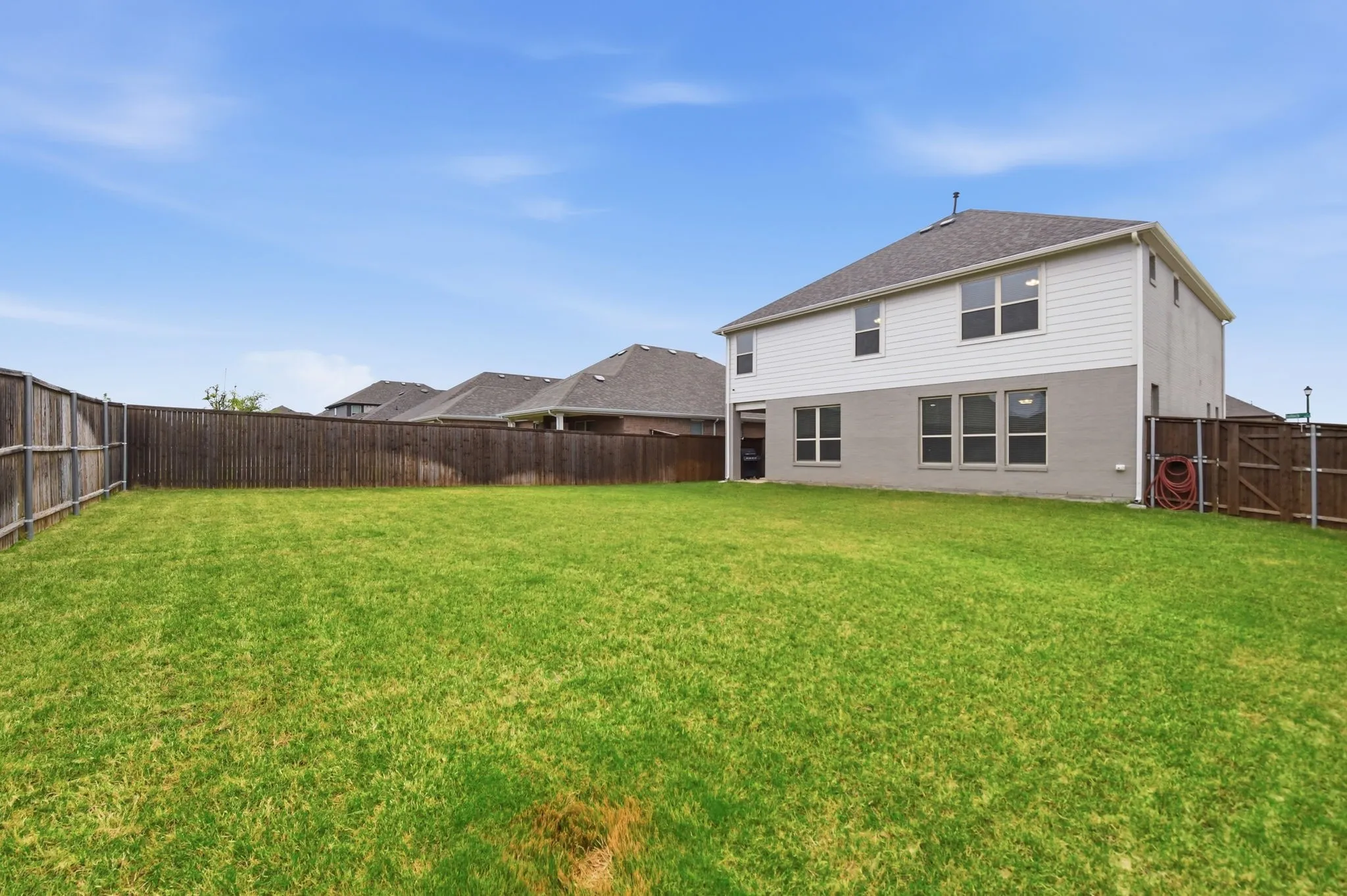 Rear view of house featuring a fenced backyard and a gate