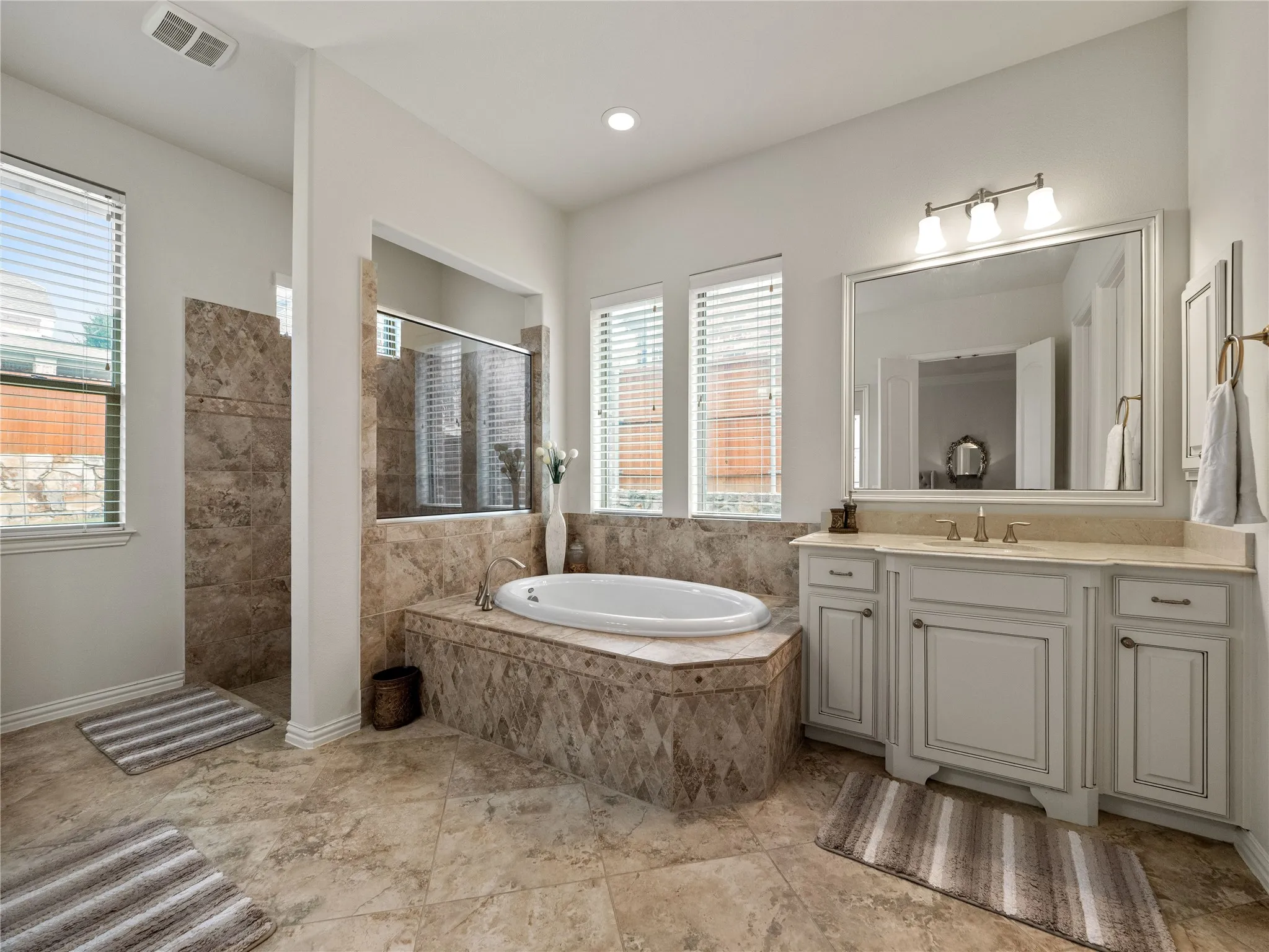 Bathroom with a walk in shower, vanity, and a garden tub
