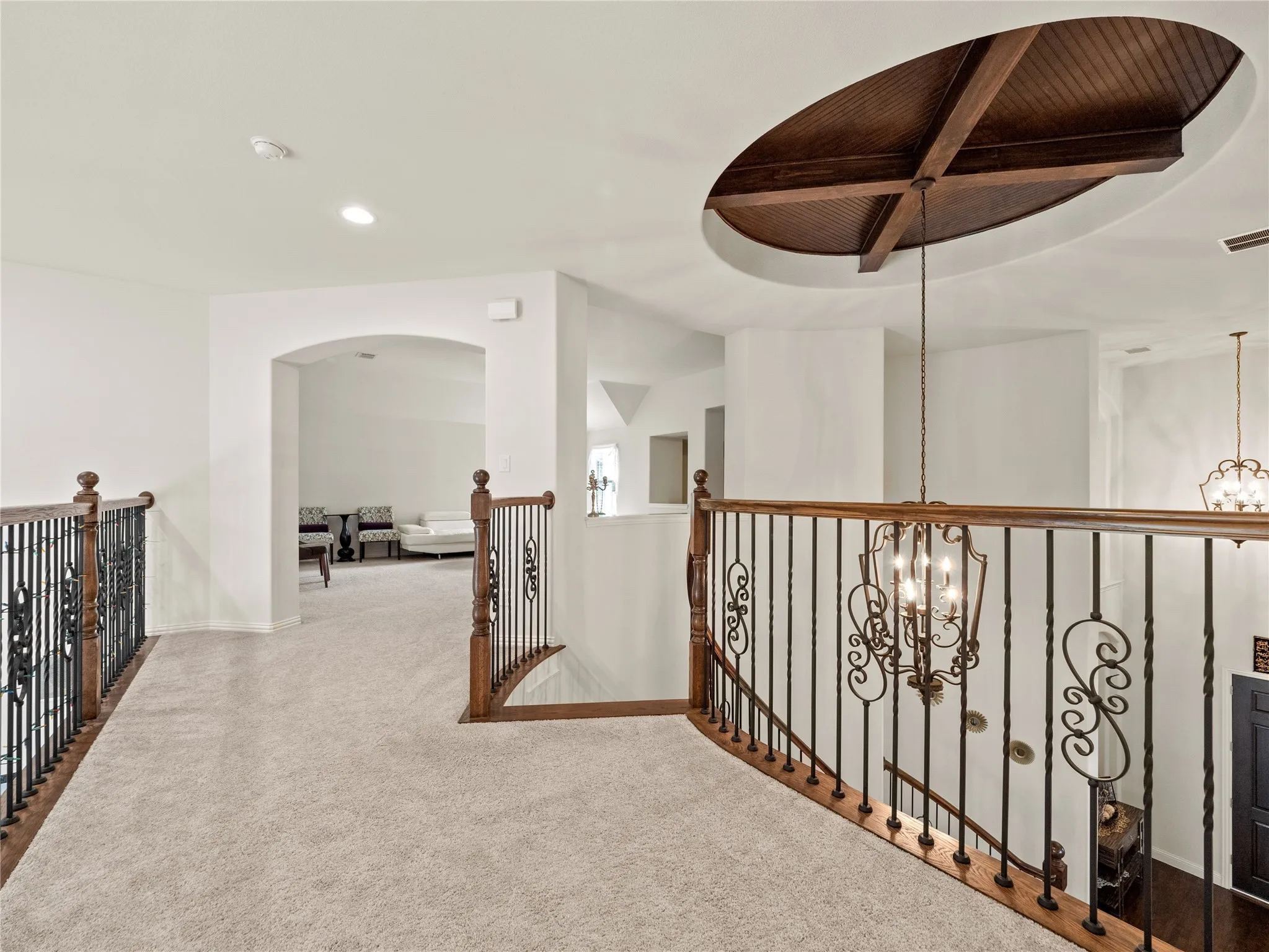 Corridor featuring hanging lights, carpet floors, and an upstairs landing