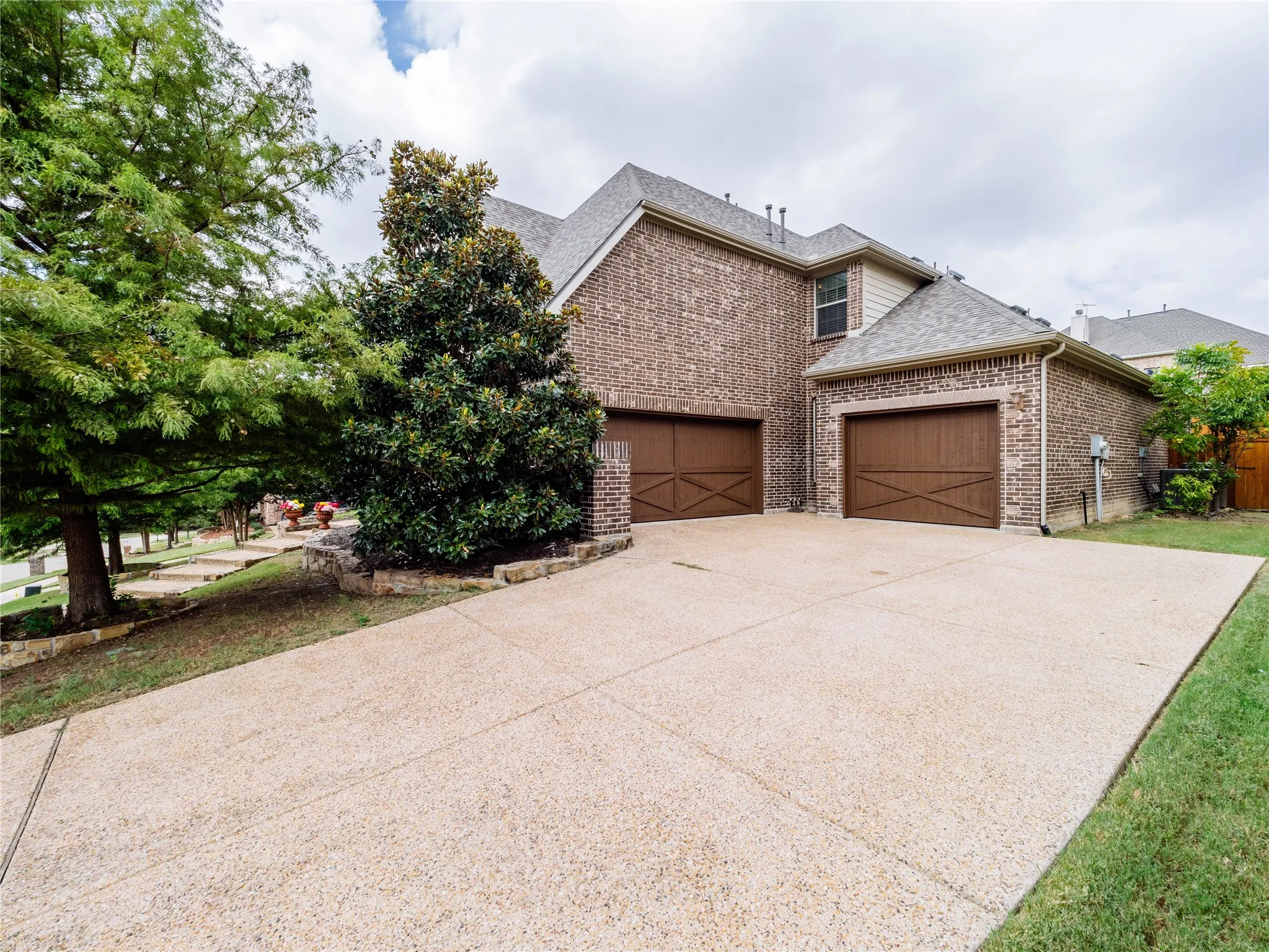 View of front of home featuring brick siding, a garage, concrete driveway, and a shingled roof