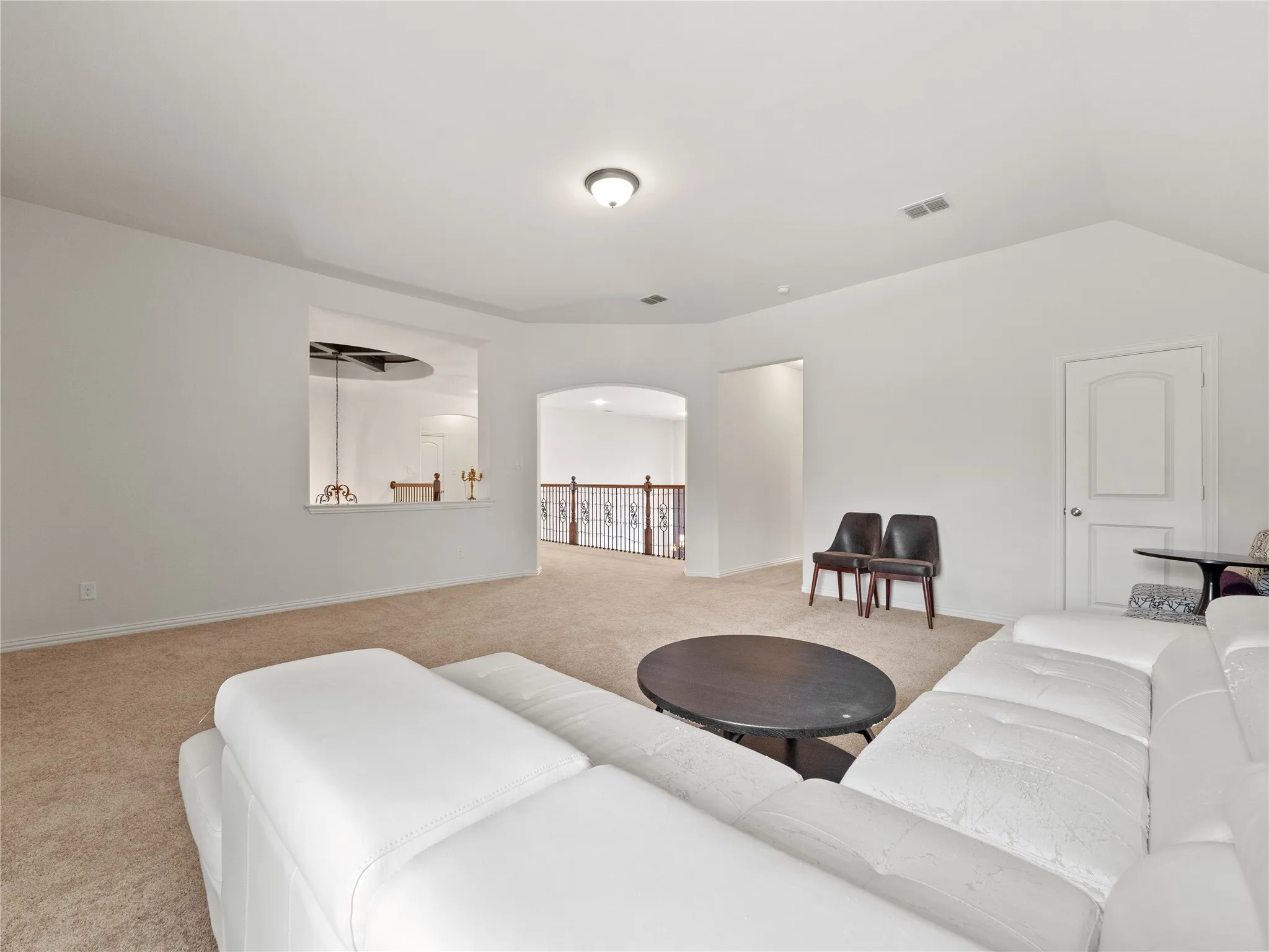Living area featuring light carpet and arched walkways