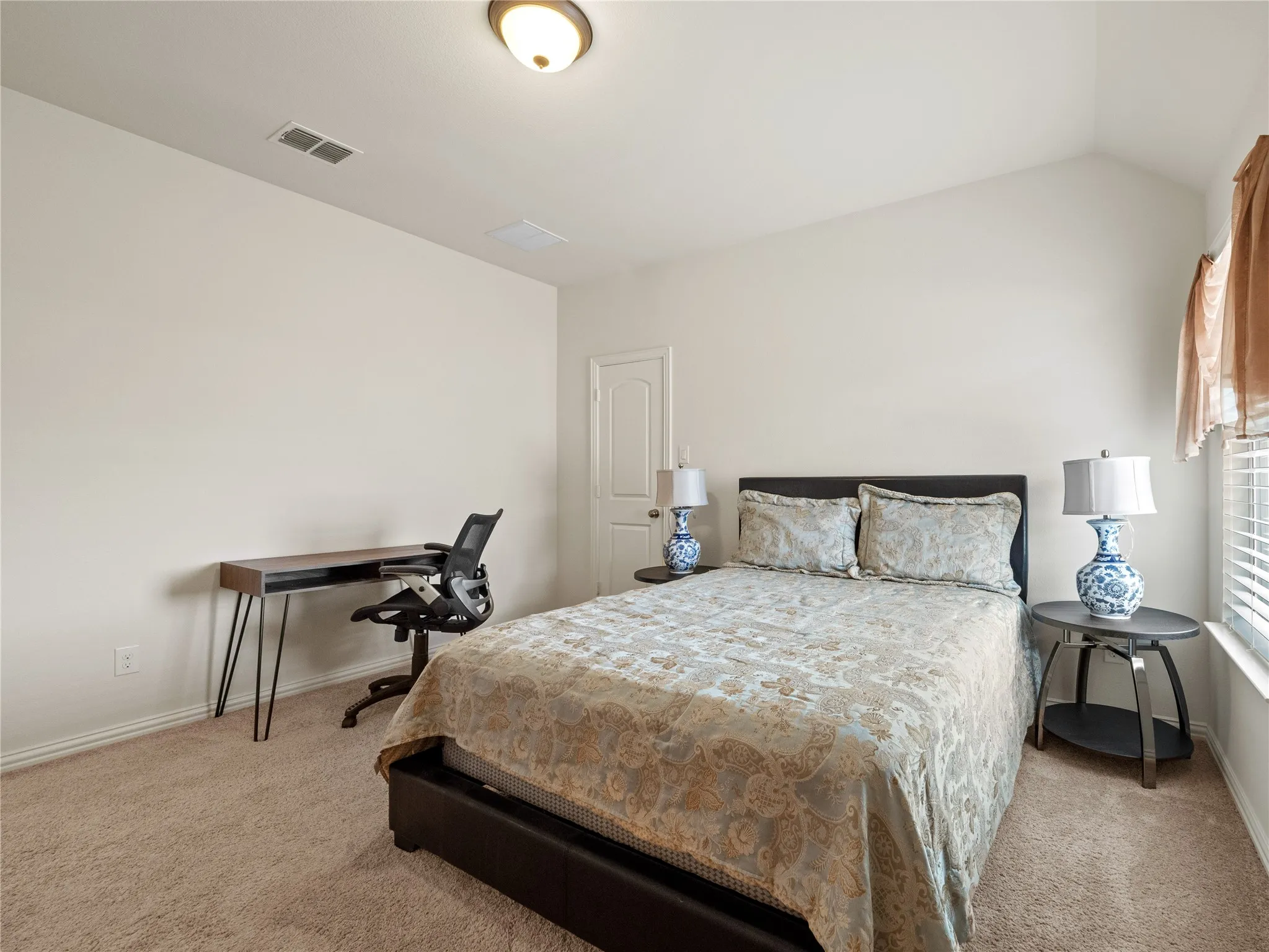 Bedroom featuring light carpet and vaulted ceiling