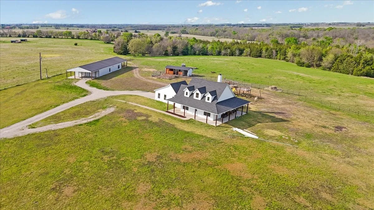 Aerial view of Main home, Loafing shed with 2 stalls and corrals, 40X50 Workshop with 40X20 covered carport and 2nd residence with 2000+- SF and a 20X20 covered back patio