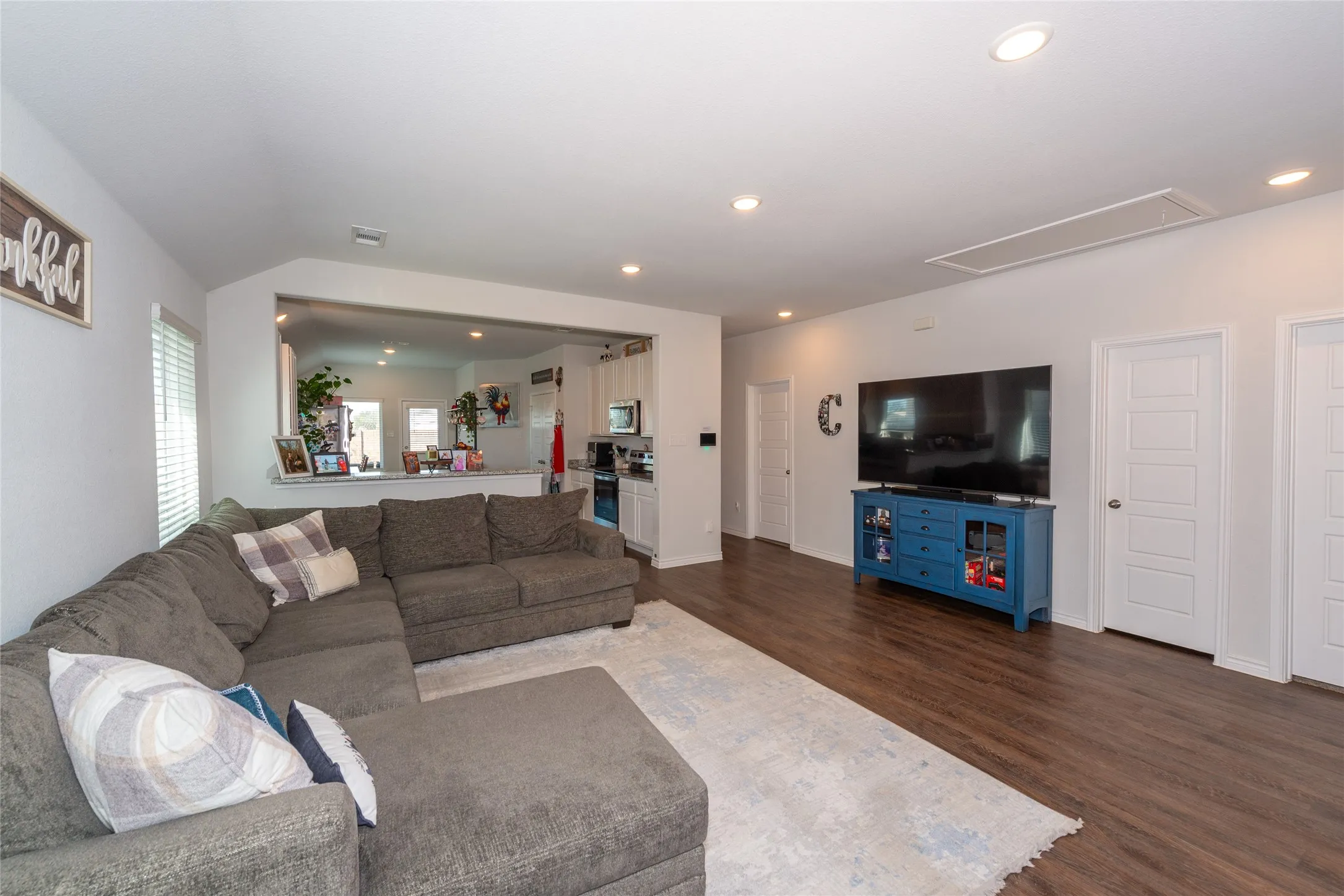 Living room featuring dark wood-type flooring and recessed lighting