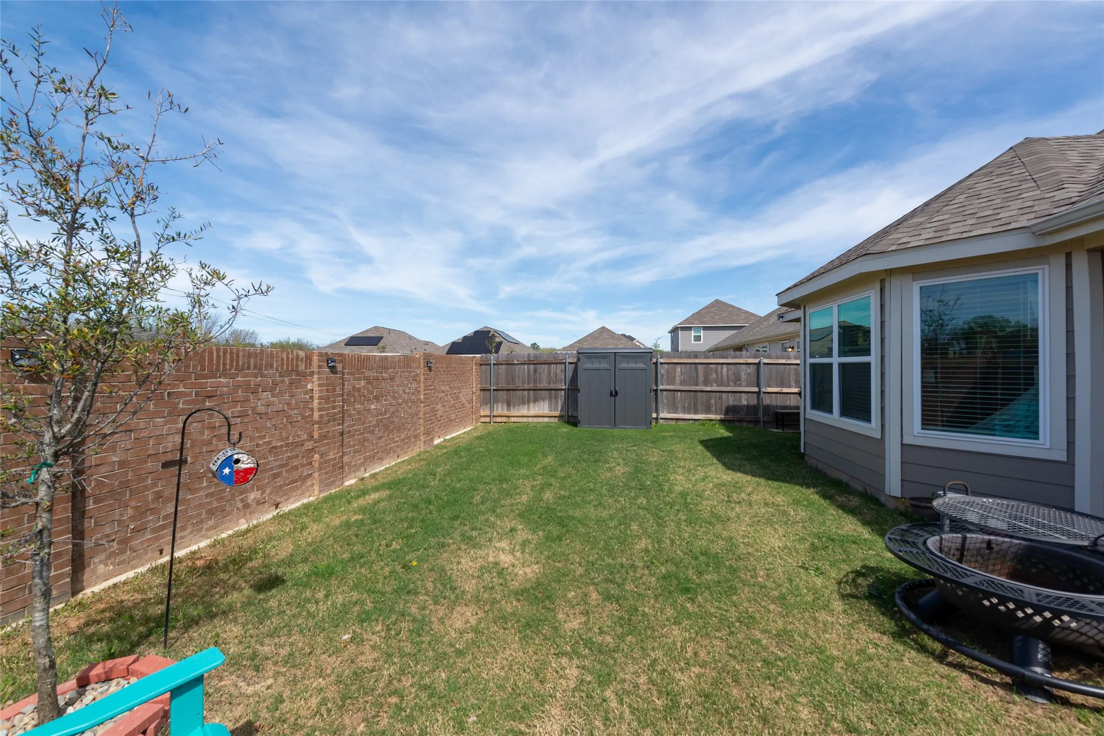 Fenced backyard with a shed and a residential view