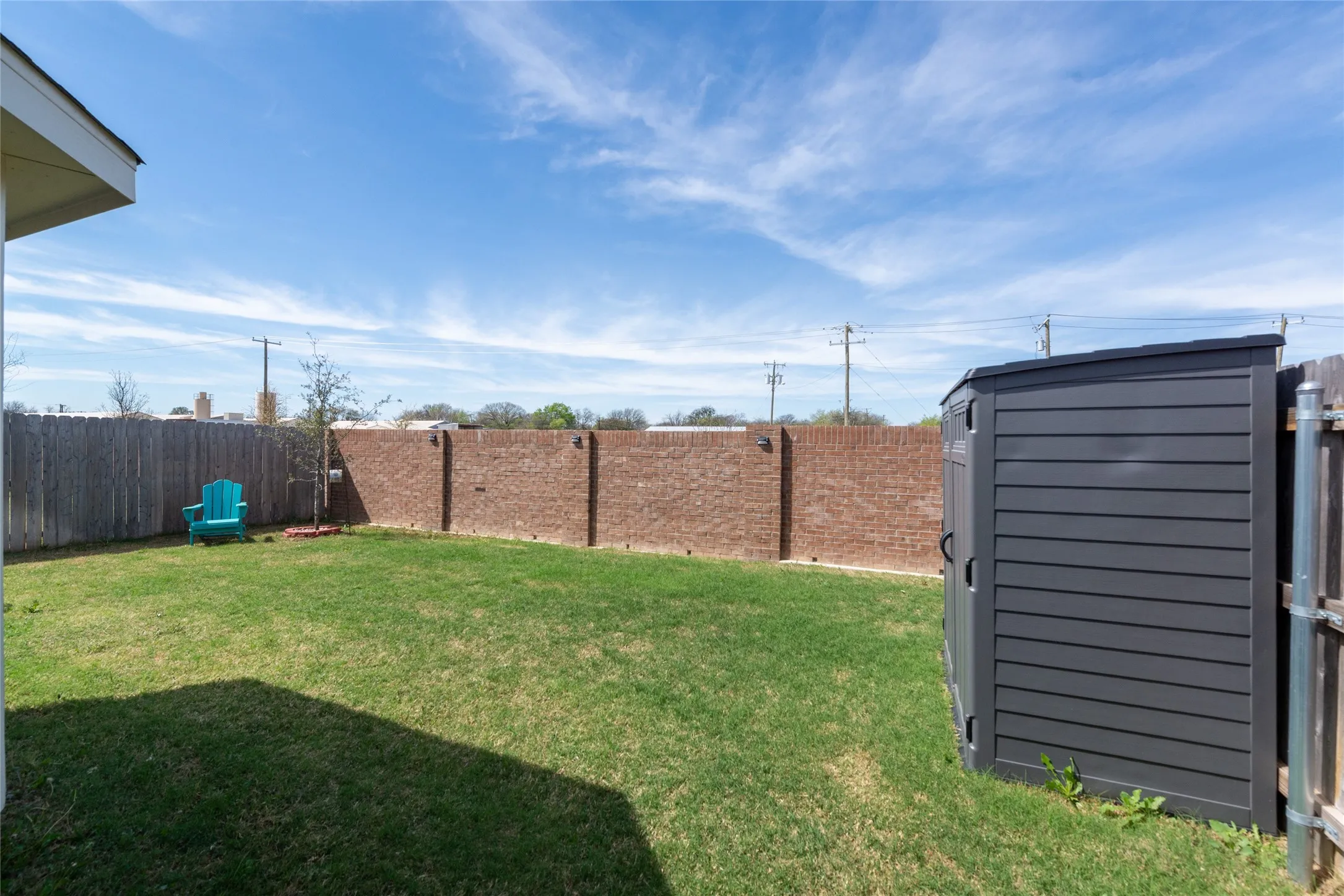 Fenced backyard with a storage shed