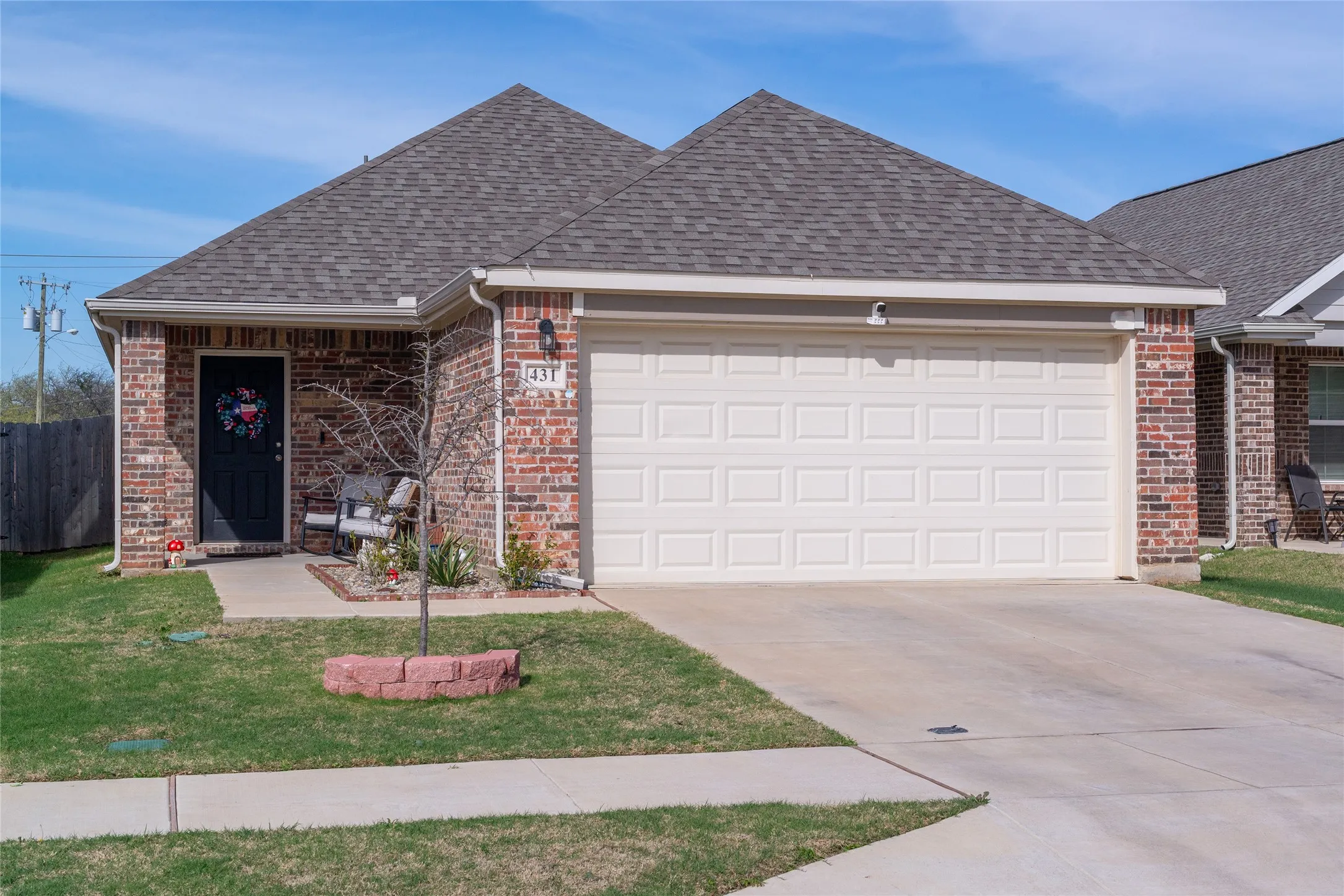 Single story home featuring a garage, brick siding, roof with shingles, and driveway