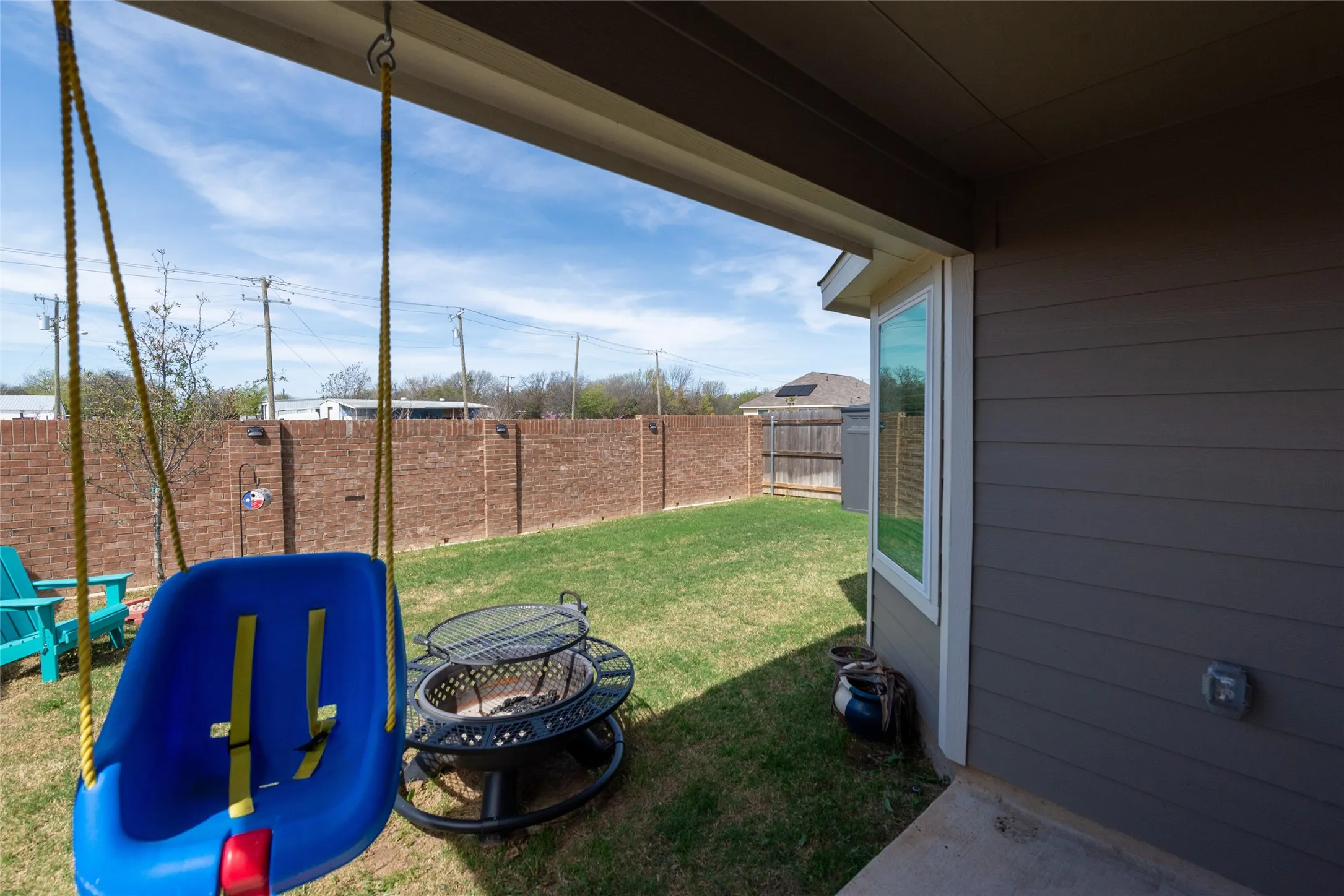 Fenced backyard with a patio and a fire pit