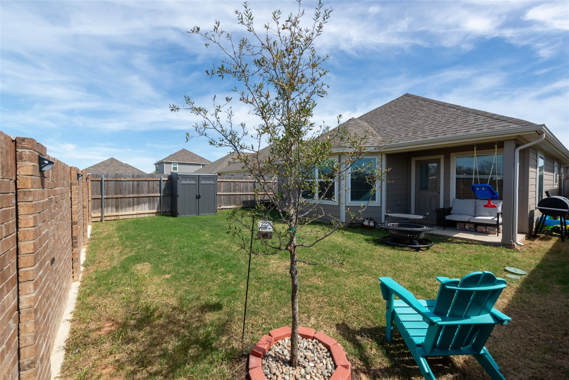 Rear view of house featuring an outdoor fire pit, a storage shed, a patio area, and a fenced backyard
