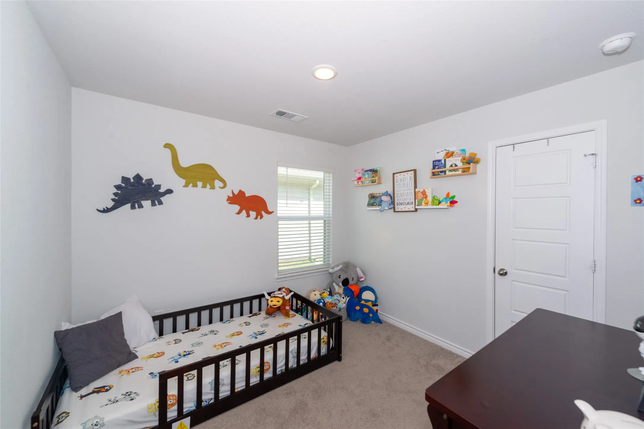 Bedroom with light carpet and a nursery area
