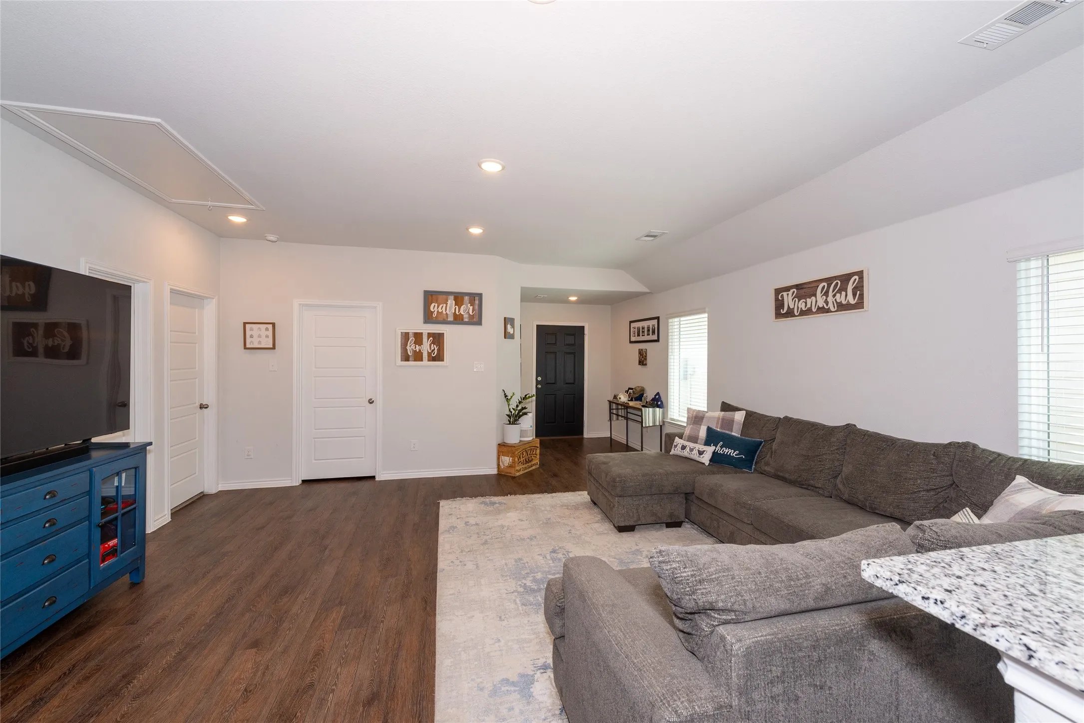 Living area featuring dark wood-style floors and recessed lighting