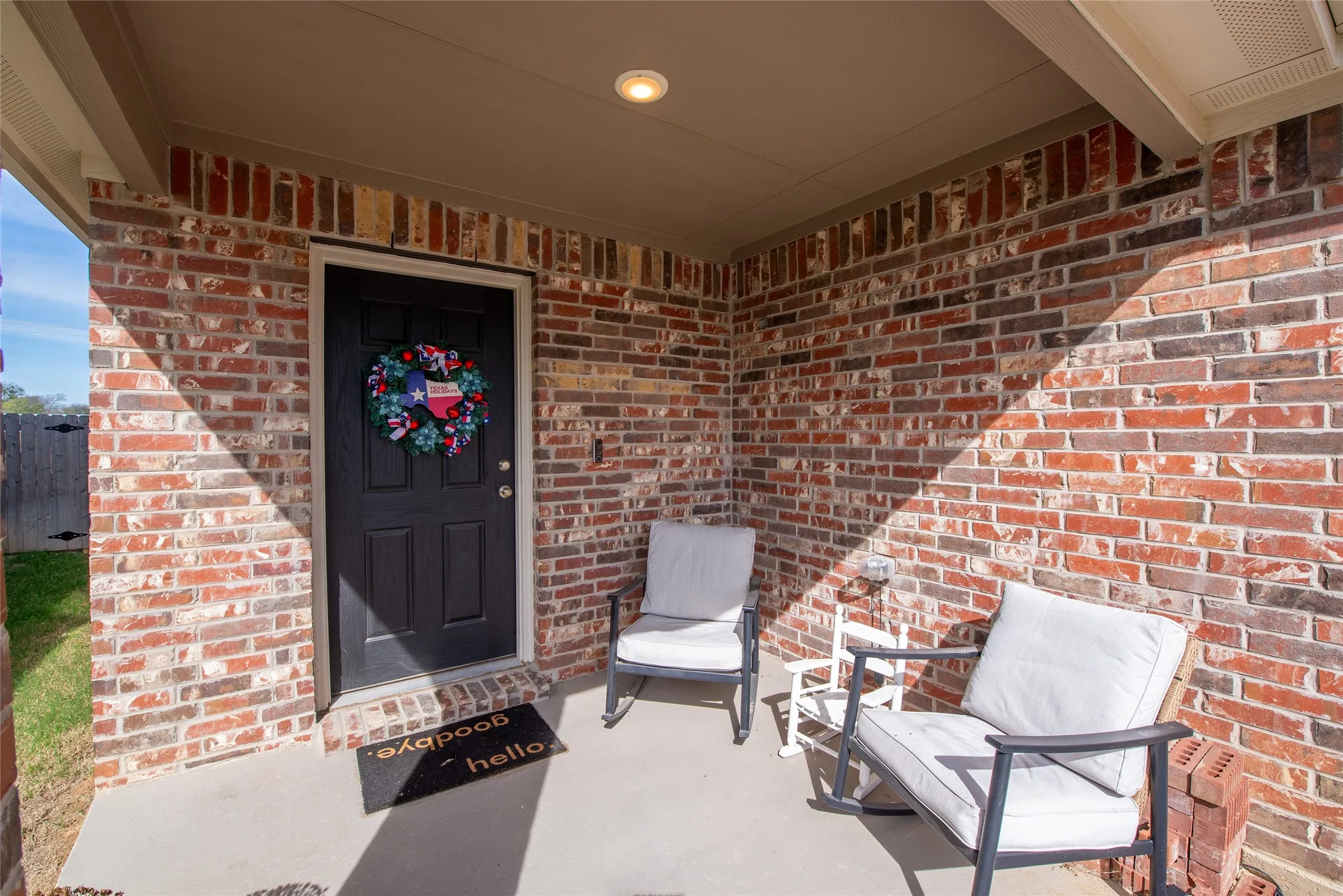 Property entrance with brick siding and covered porch