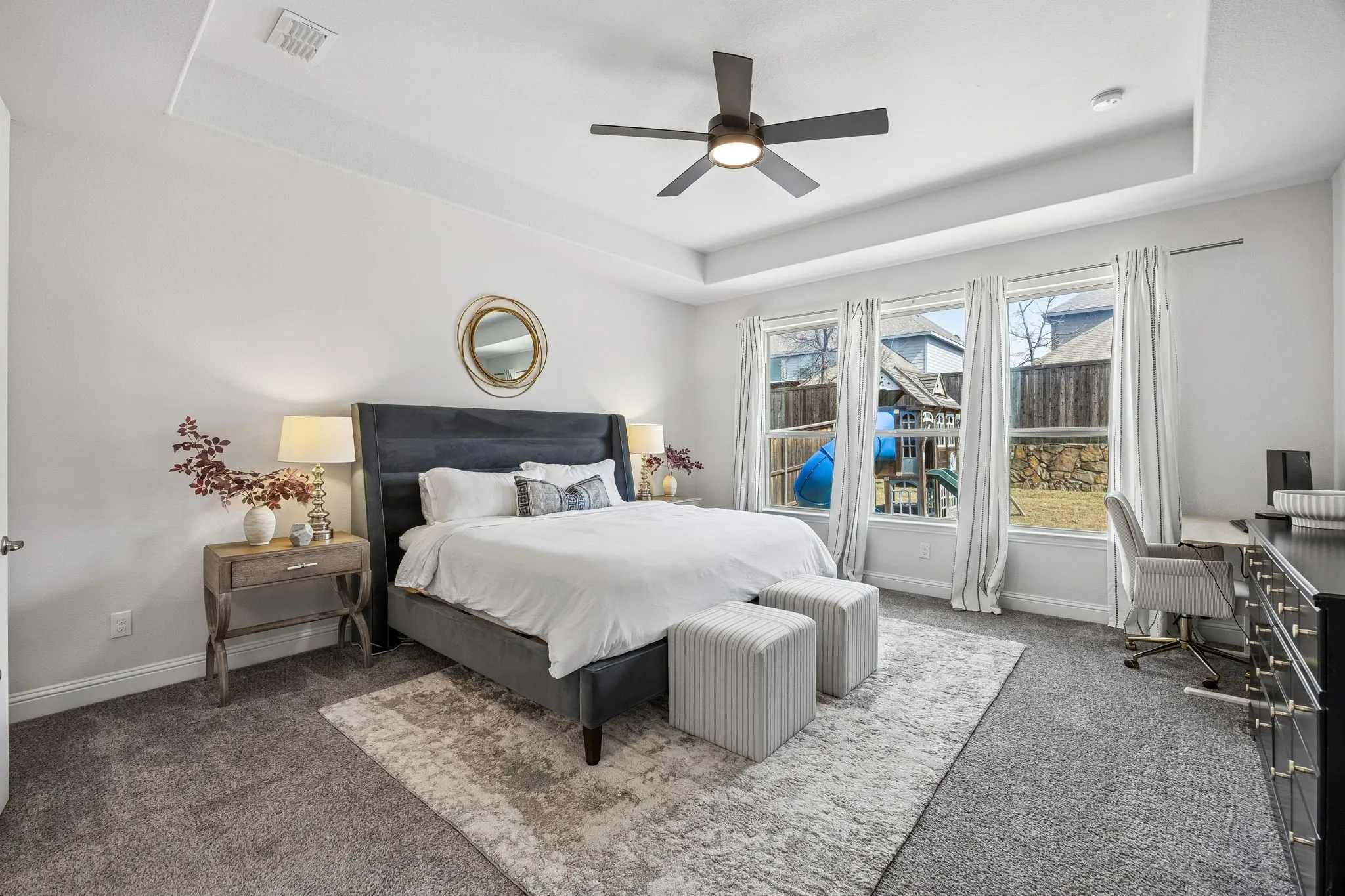 Bedroom with carpet flooring, a raised ceiling, a desk, and ceiling fan