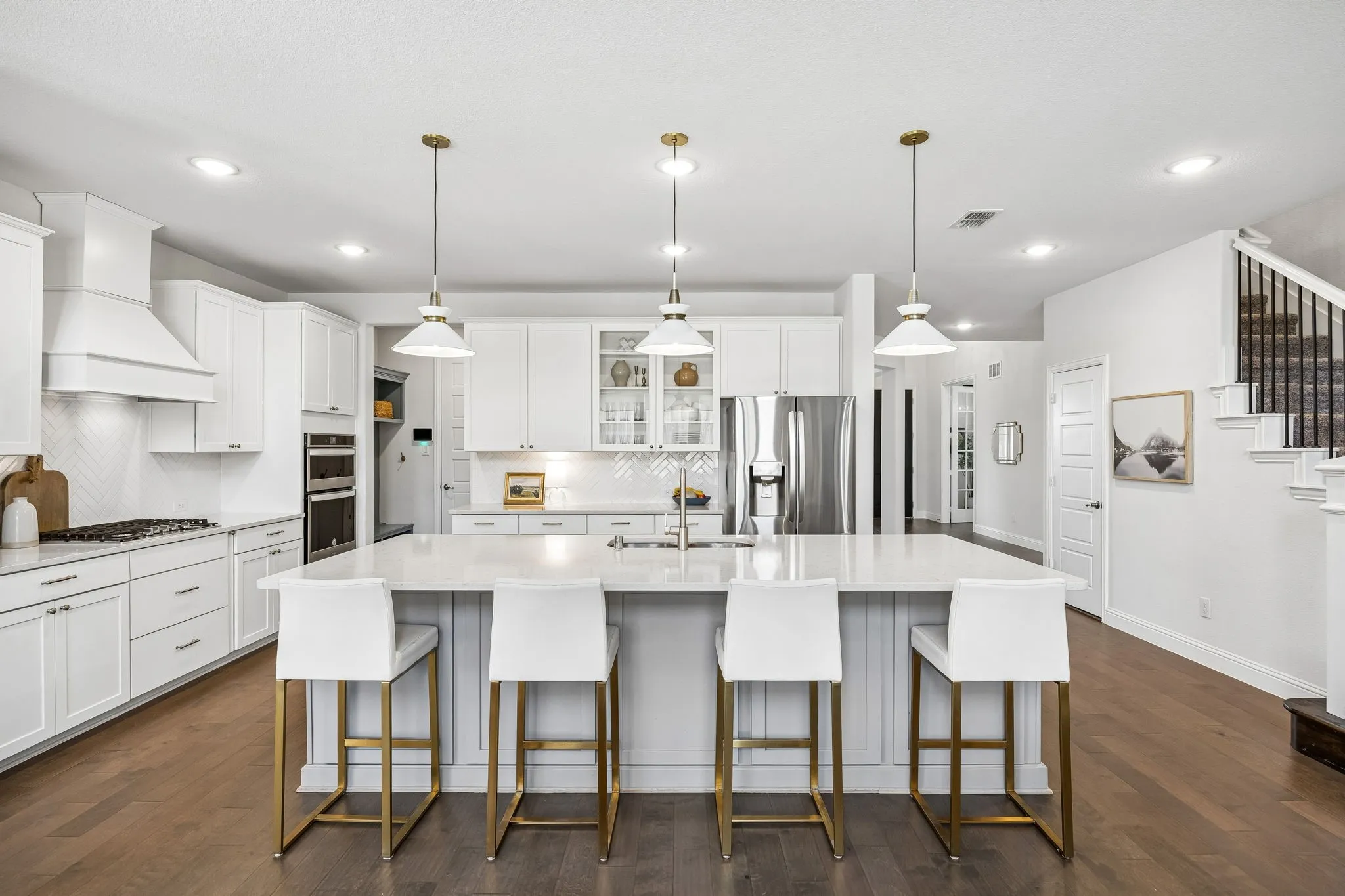 Kitchen featuring glass fronted cabinets, a large island, stainless steel appliances, white cabinets, and dark wood finished floors