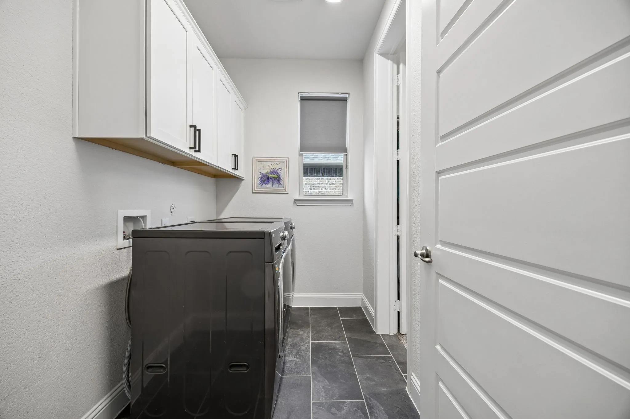 Laundry area with cabinet space and washer hookup. Walk-in Closet is connected to Utility room