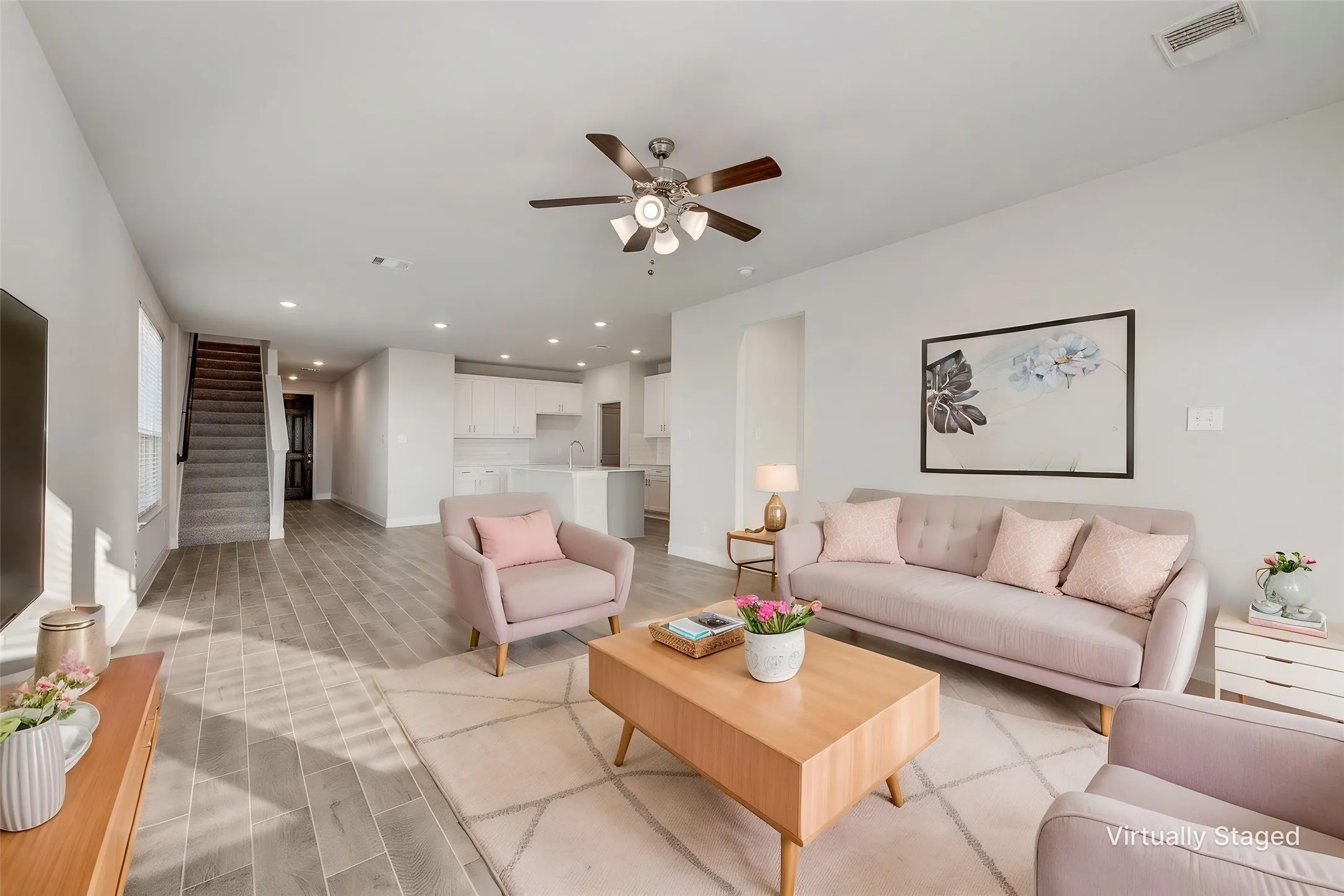 Open-concept living area featuring wood-look tile flooring, recessed lighting, and a ceiling fan