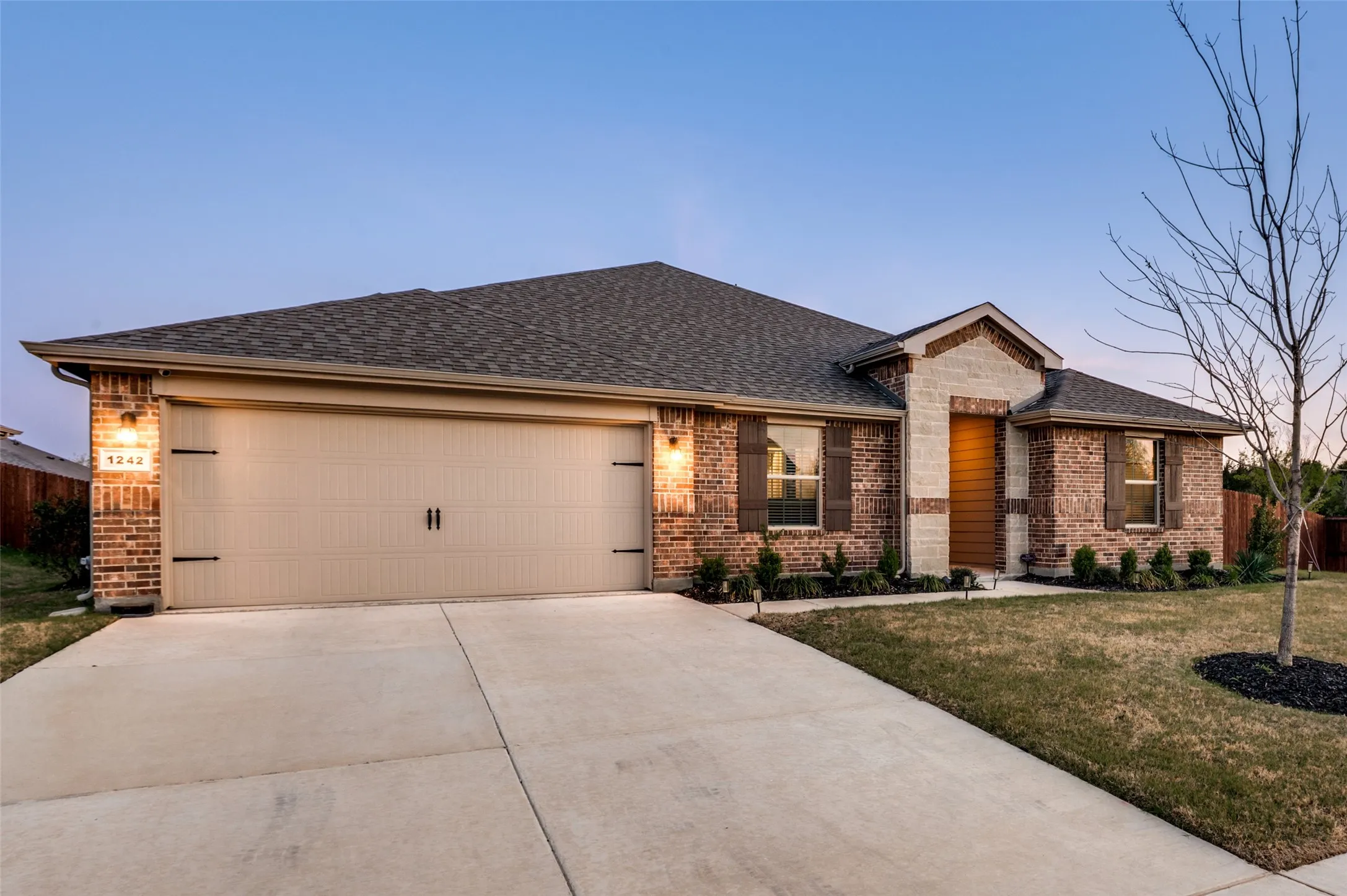 View of front of property featuring brick siding, a garage, concrete driveway, and roof with shingles